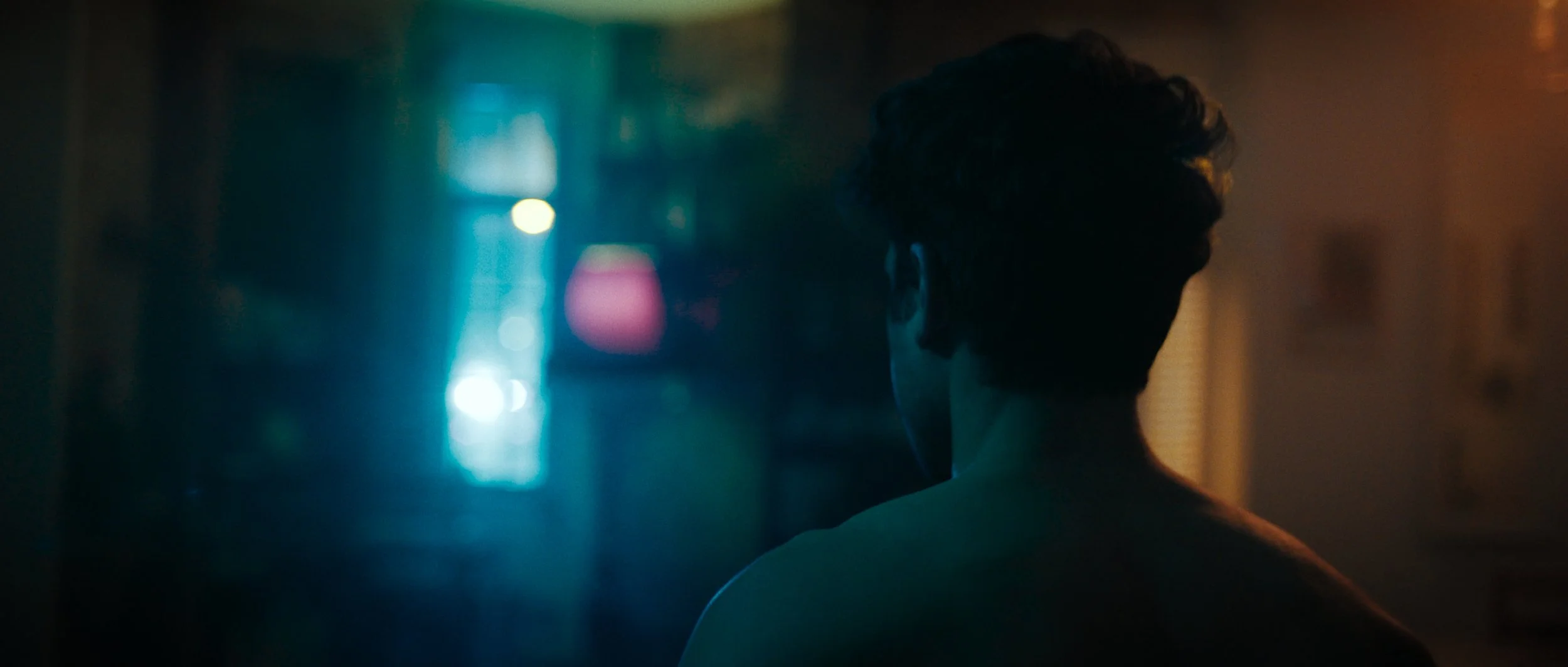A man walks through a dimly lit living room towards a window with flashing police sirens, Night Whispers