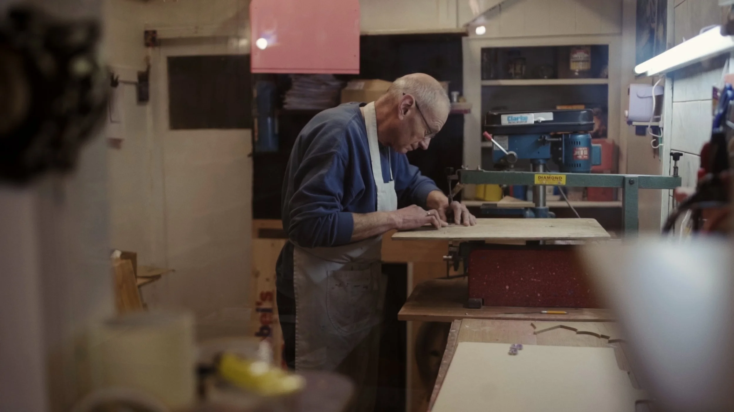 An elderly man works at a wood-cutting machine, The Last Toymaker