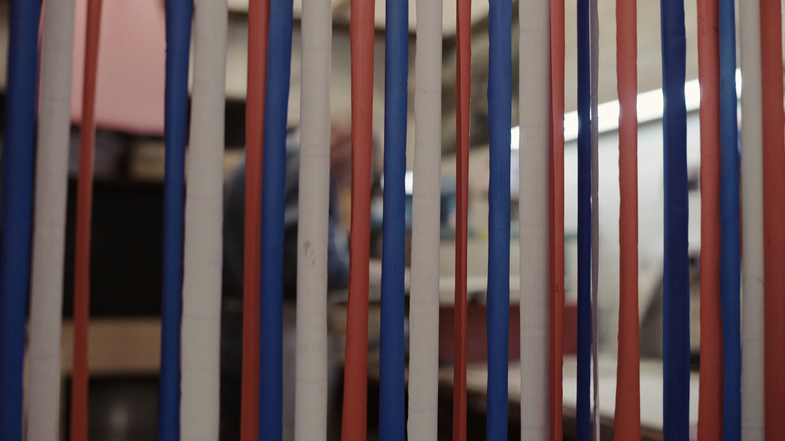 A set of red, blue and white pieces of fabric hang from a doorframe, The Last Toymaker