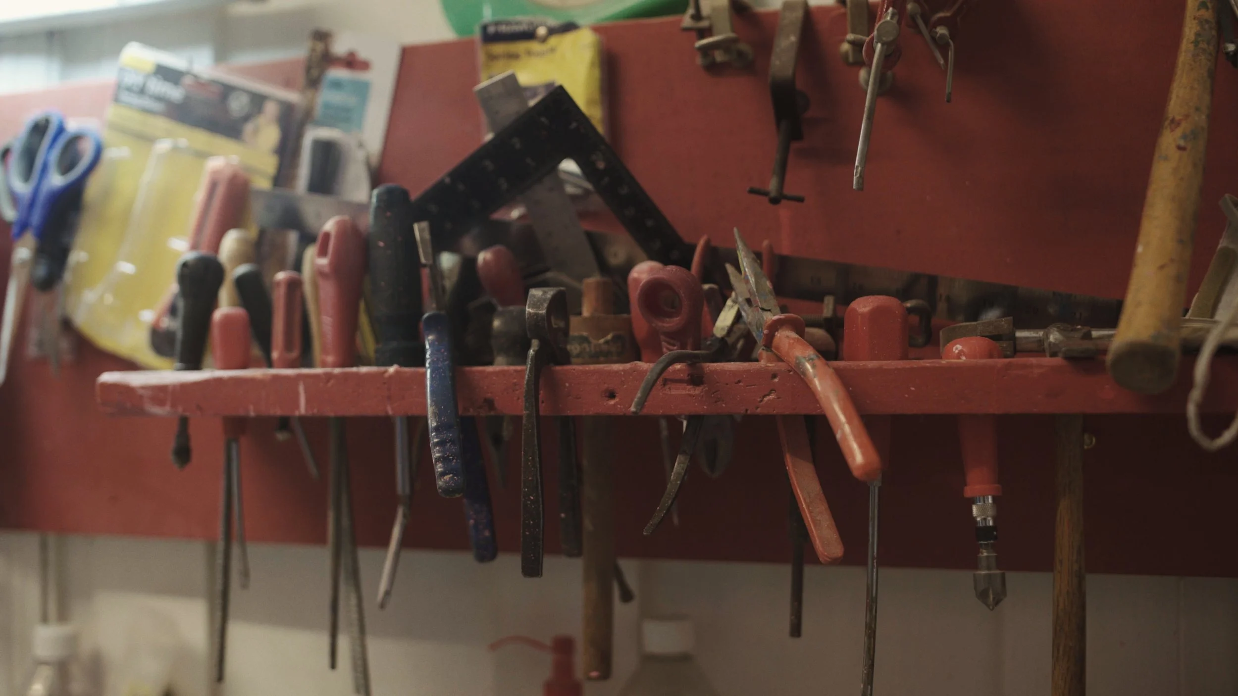 A range of tools sit on a red tool organiser, The Last Toymaker