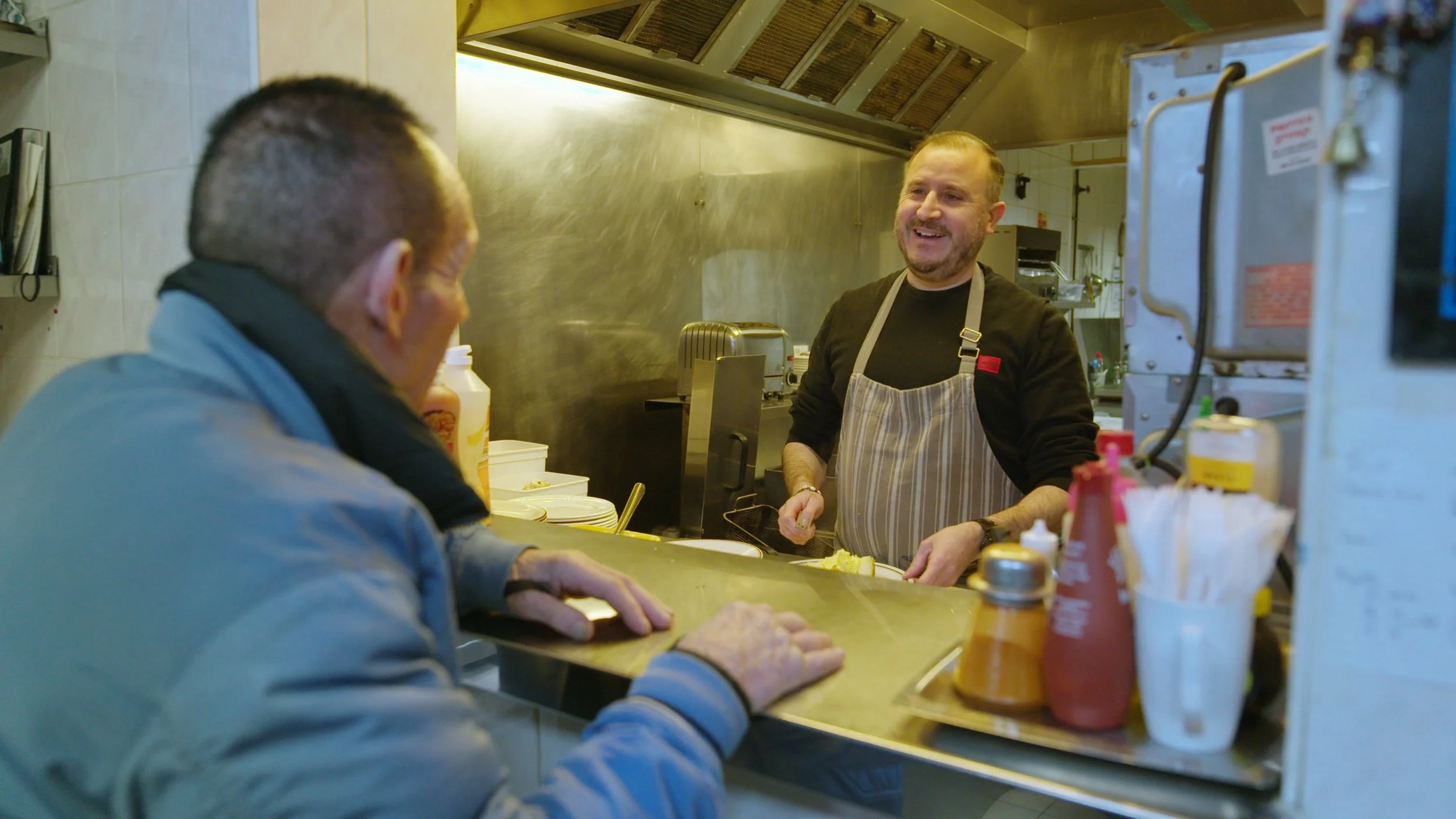 King Dick (Brian Jason) and Eddie chat in the kitchen