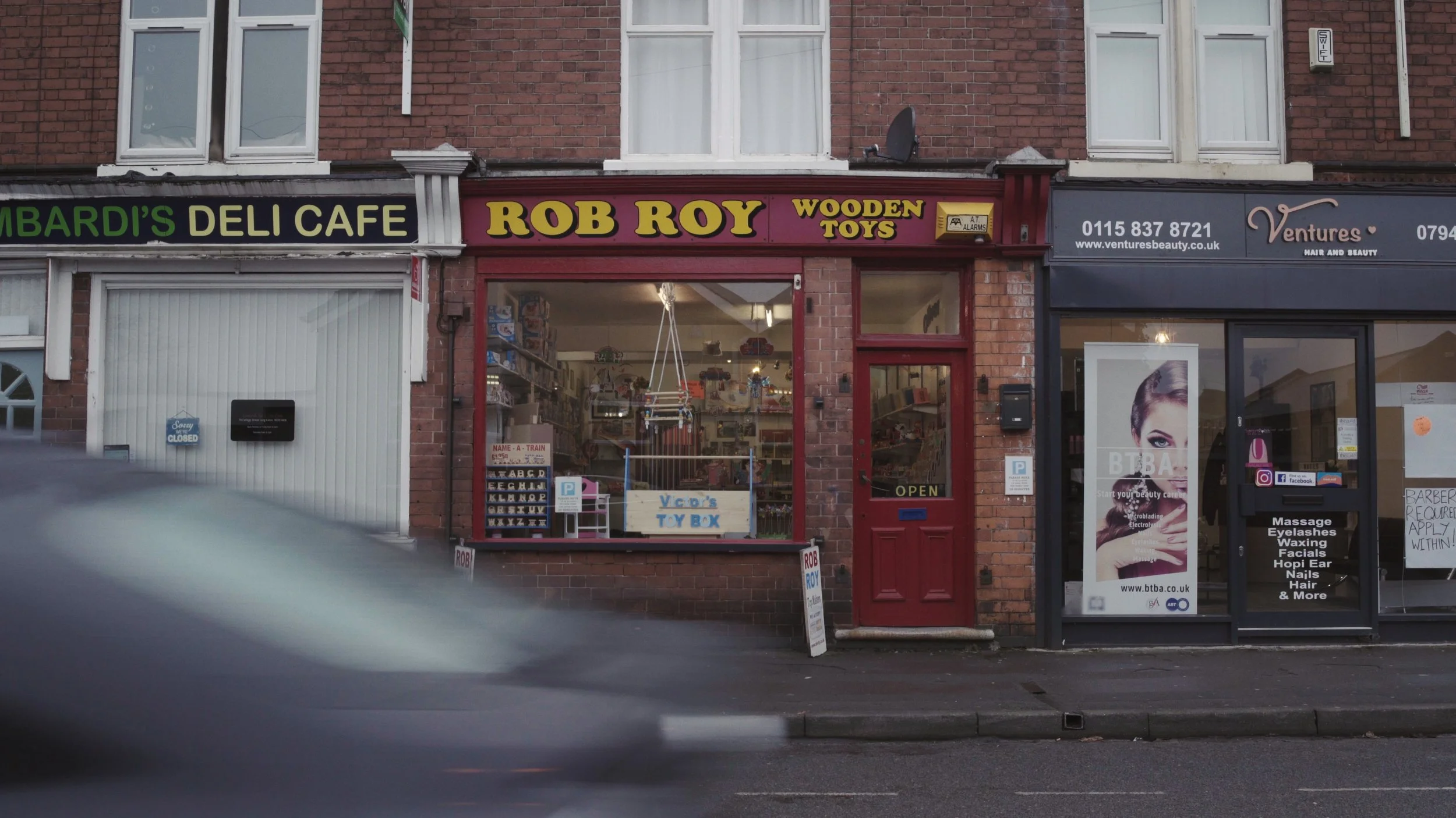 Rob Roy Toy Makers from outside as a black car drives past, The Last Toymaker