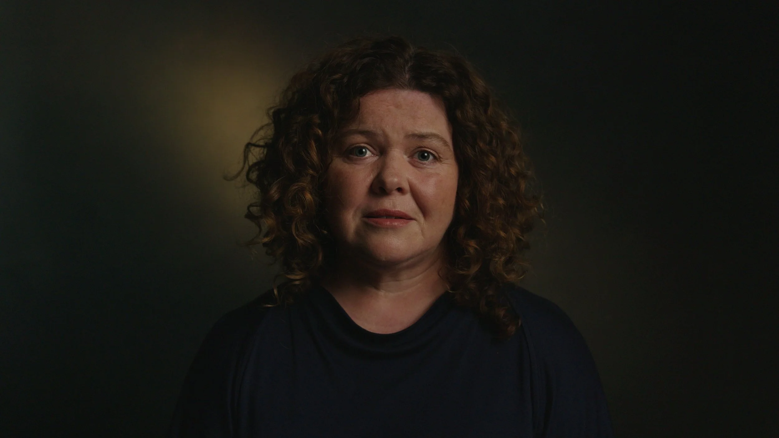 A woman looks into camera in-front a dark backdrop, It's Not Just Banter