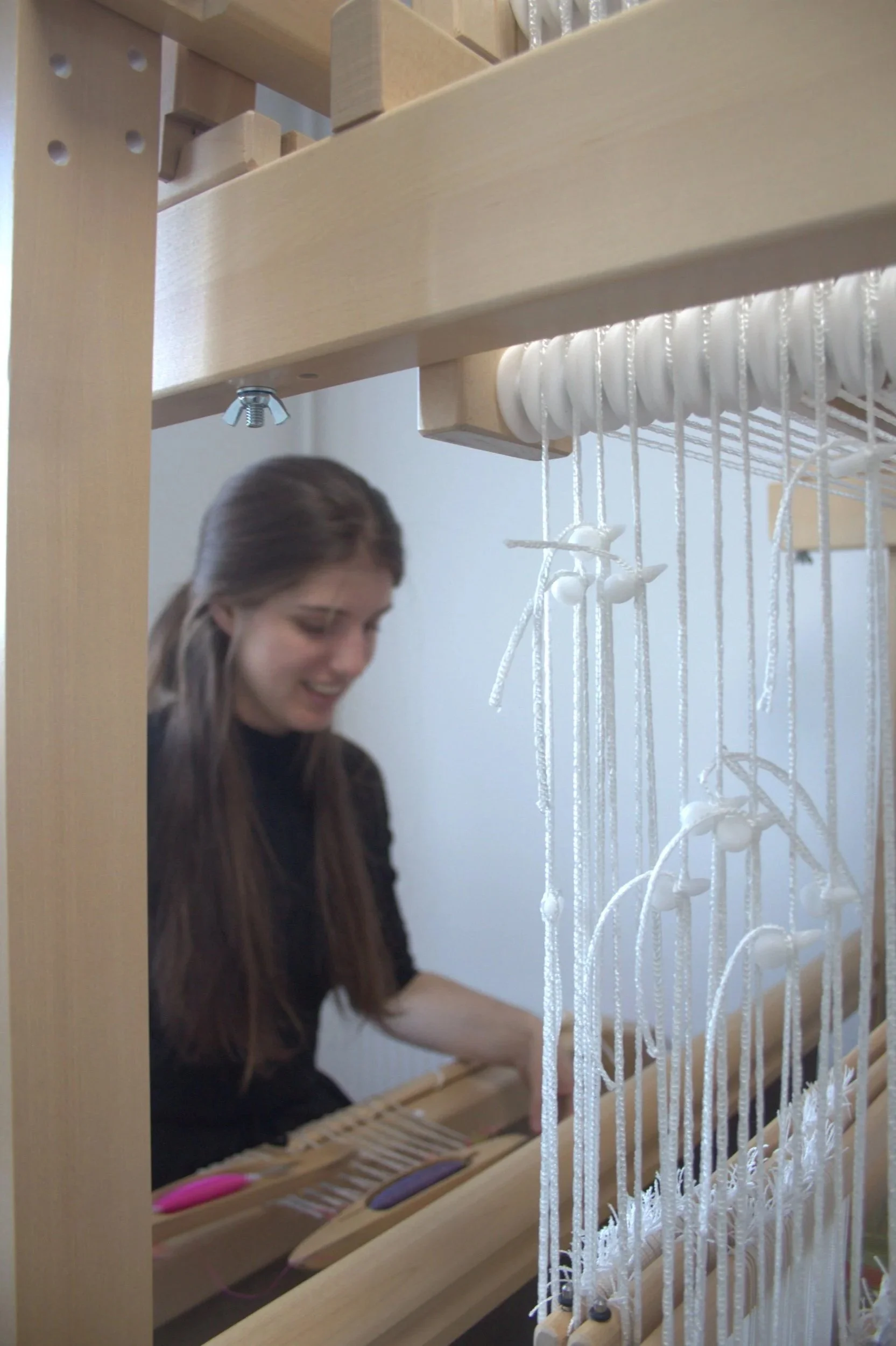 Helena Powell weaving at her loom, with hand dyed silk and on a computer dobby hand loom