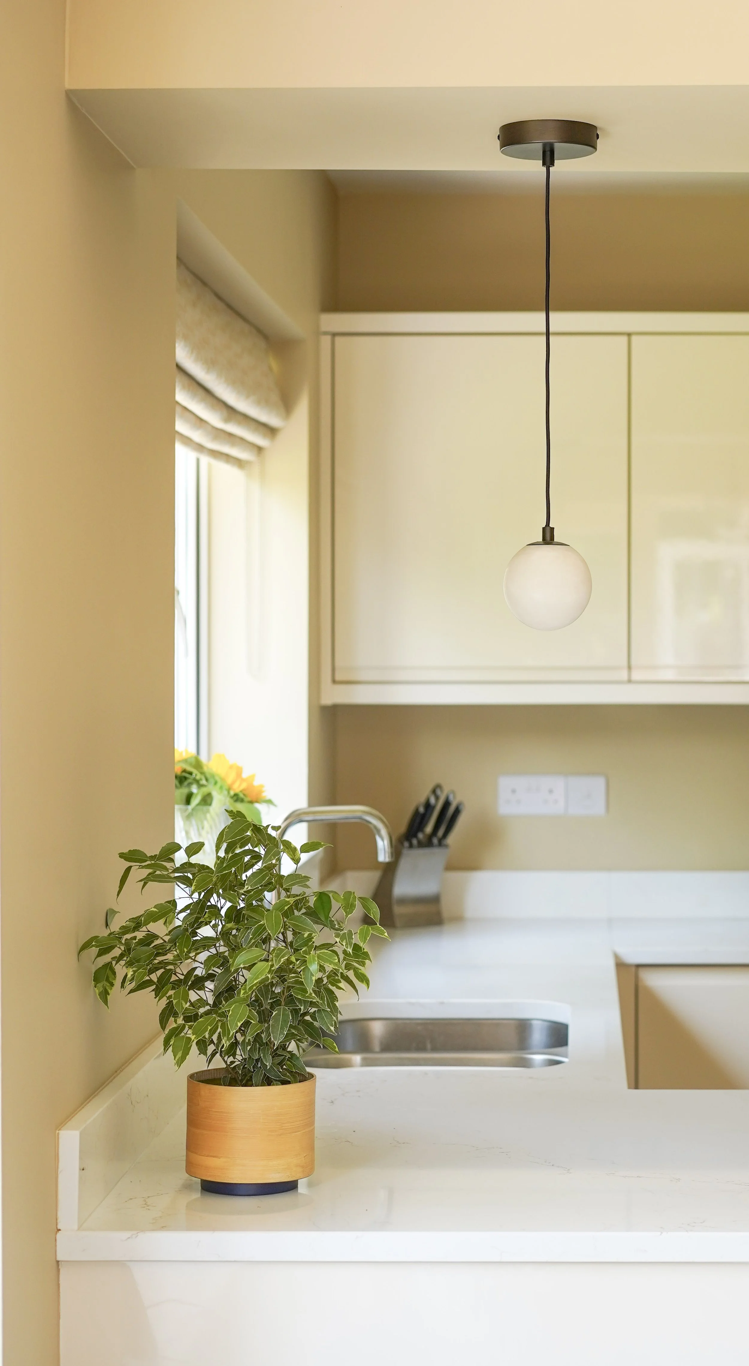 Globe alabaster pendant light against a Farrow and Ball Cord painted kitchen wall