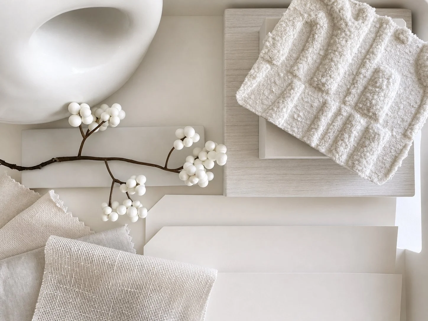 White interior textures including linen, boucle and pale timber layered together