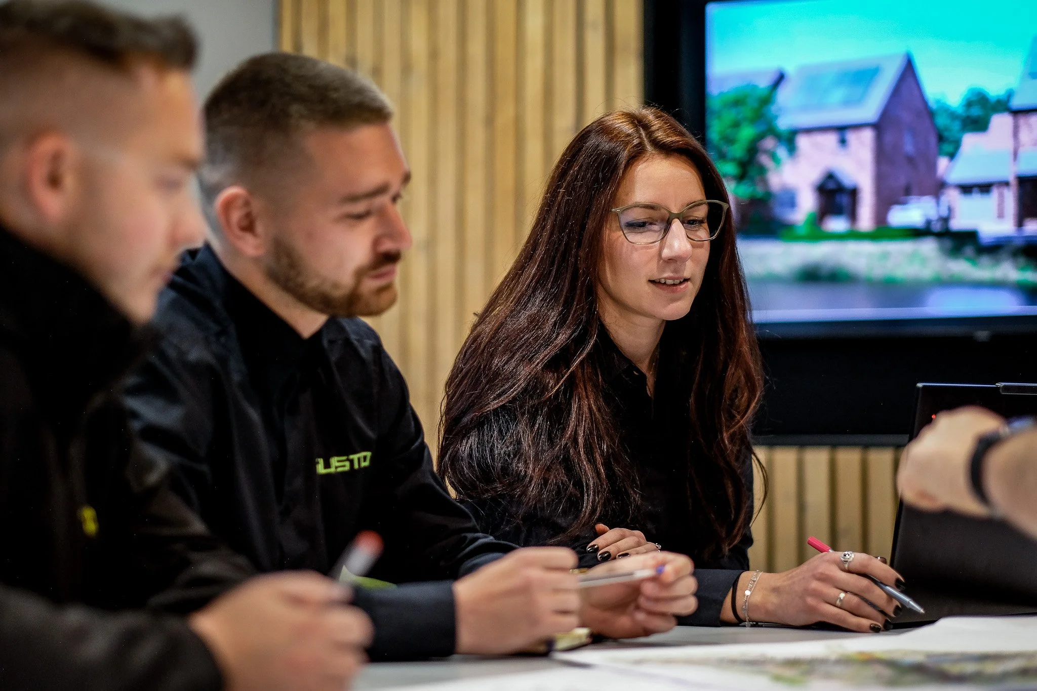 Gusto Construction team reviewing architectural plans and development proposals in the design studio.