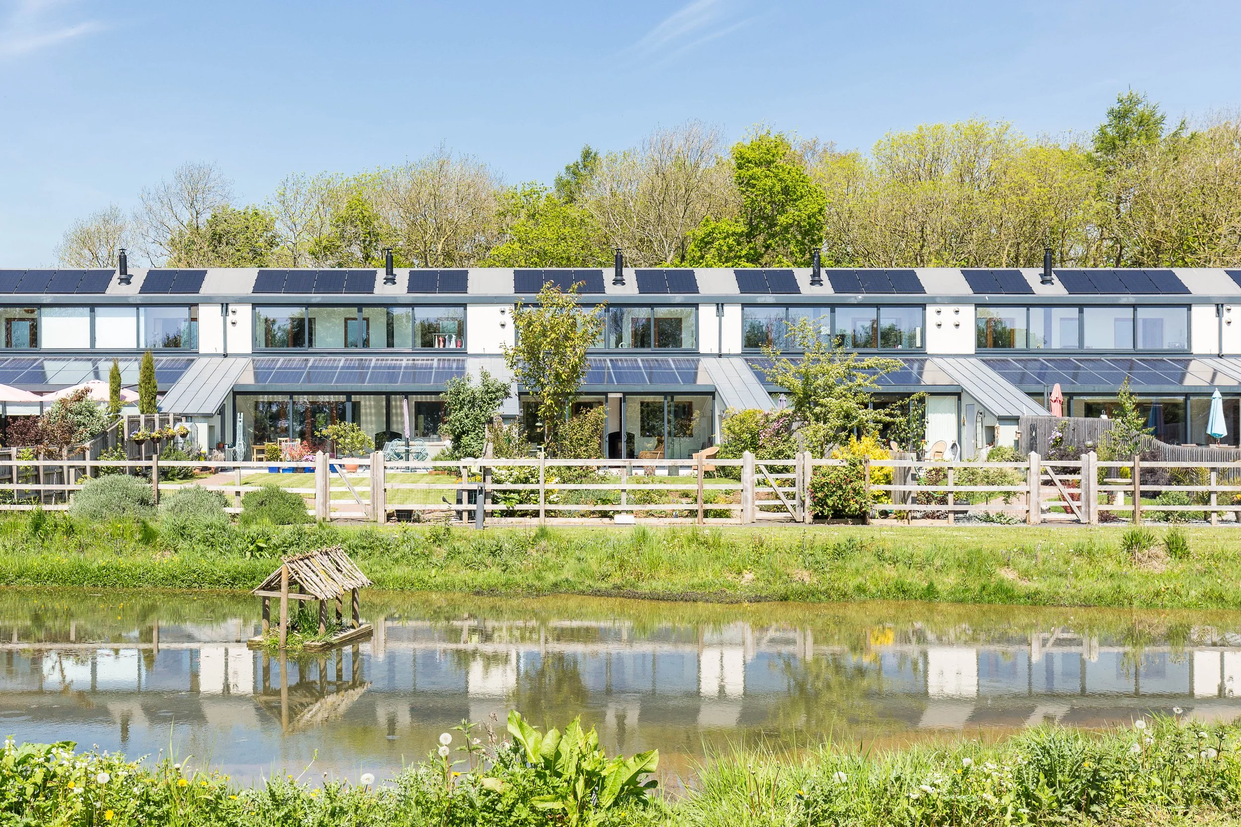 Contemporary sustainable homes with rooftop solar panels and landscaped gardens built by Gusto Construction.