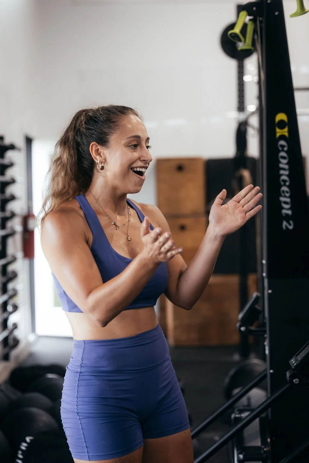 Person smiling, wearing a black "fit collection" t-shirt and a smartwatch, standing against a light background.