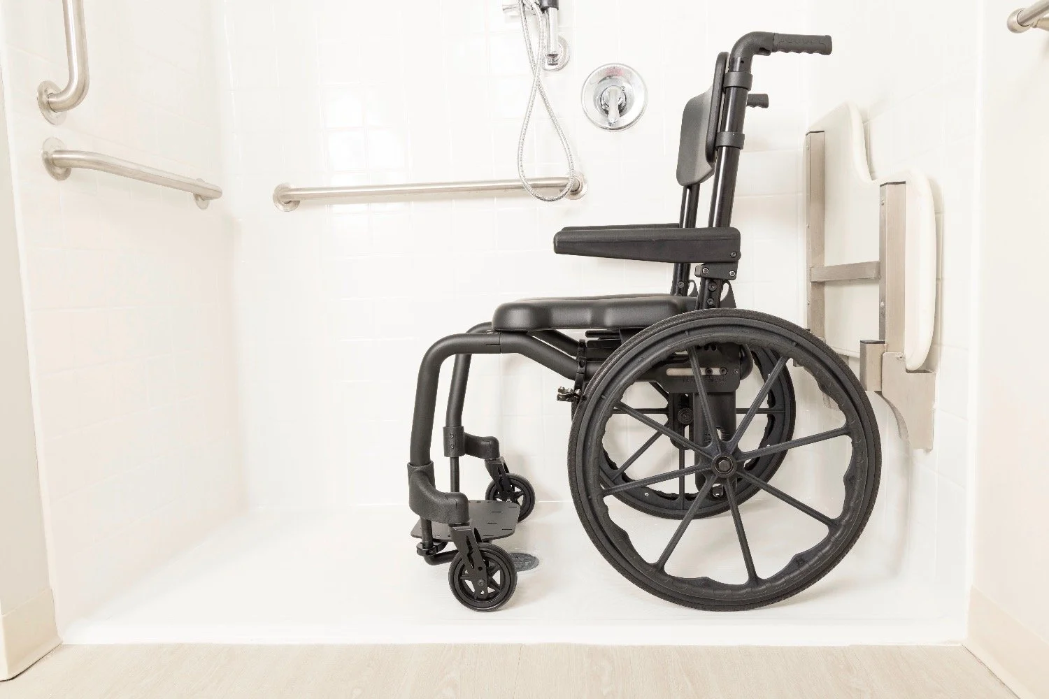 Black shower commode in a white shower.