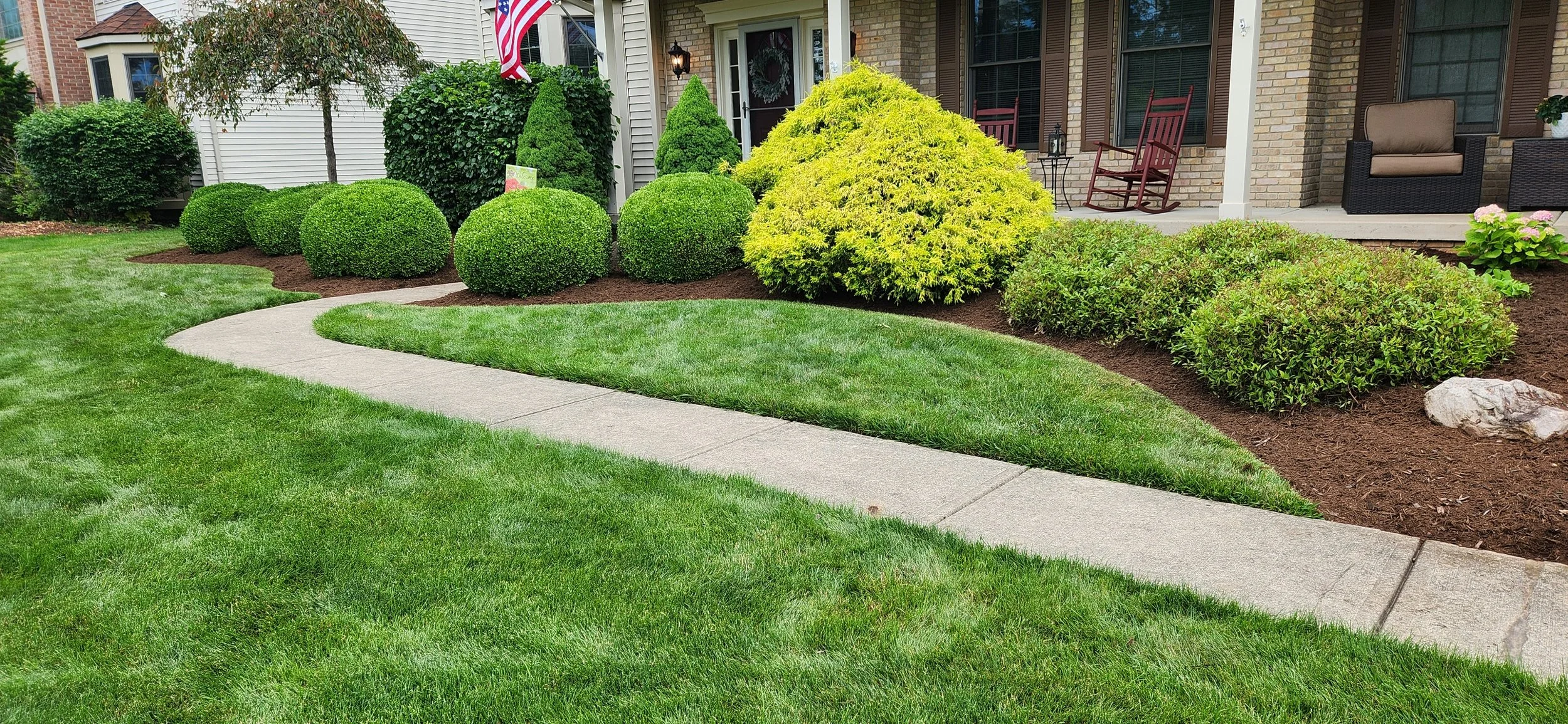 Freshly mulched residential landscape beds with maintained lawn