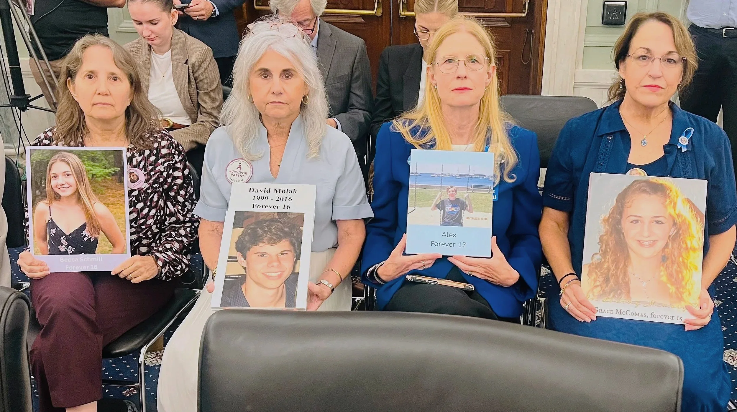 Survivor parents and ParentsSOS members at the Senate Markup of KOSA, holding picture of their children lost to online harms