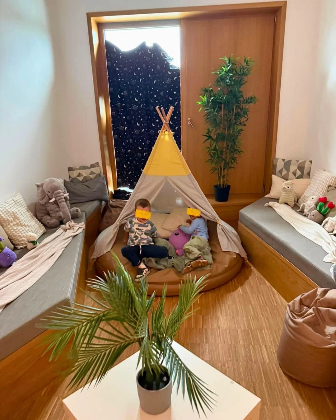Espace de motricité et de repos cocooning équipé d'un tipi jaune et de coussins pour les enfants à la crèche Les Mousquetaires de Leudelange.