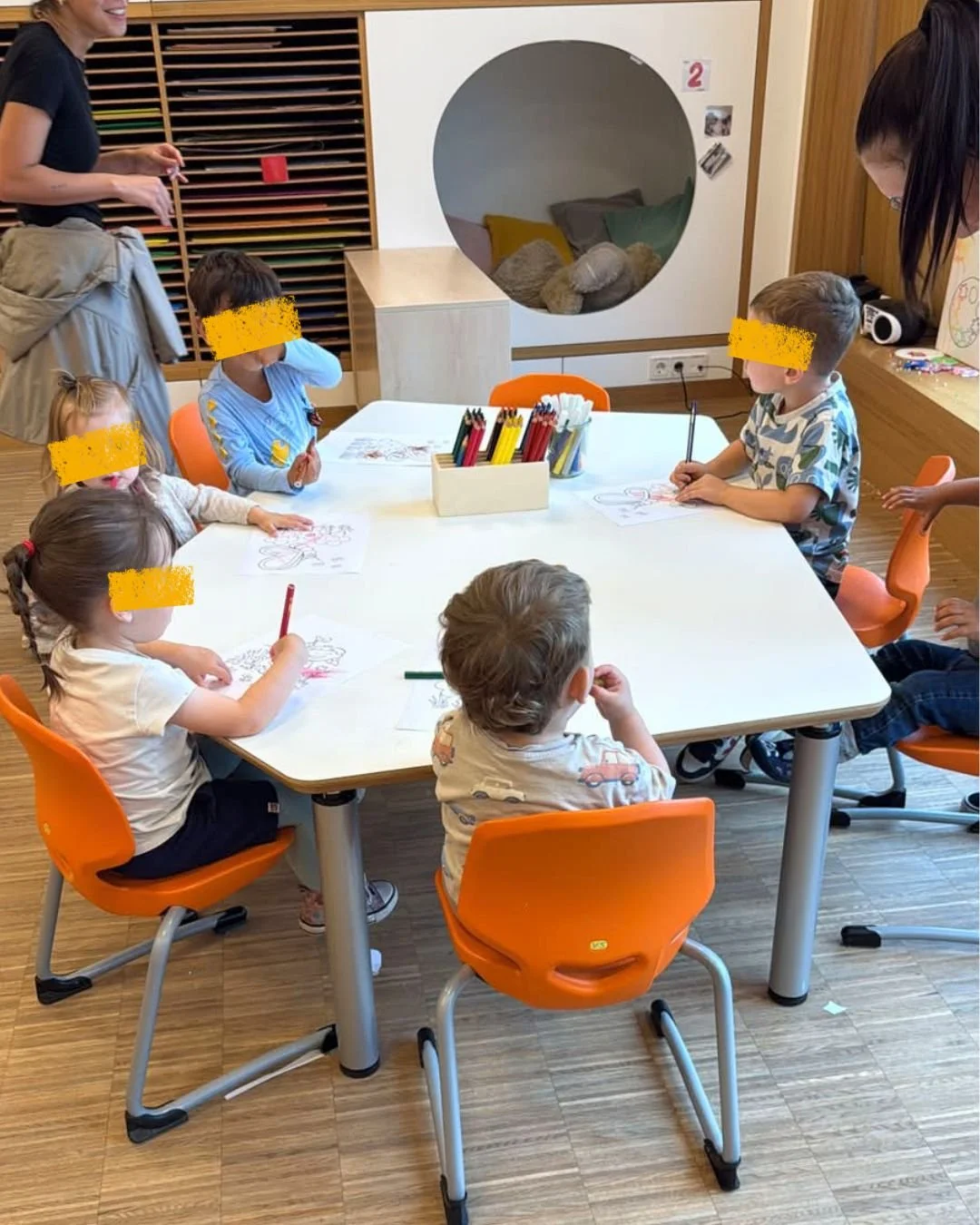 Groupe d'enfants de 3-4 ans de la Crèche Les Mousquetaires participant à un atelier de dessin et de coloriage à Leudelange, favorisant la créativité et la motricité fine.
