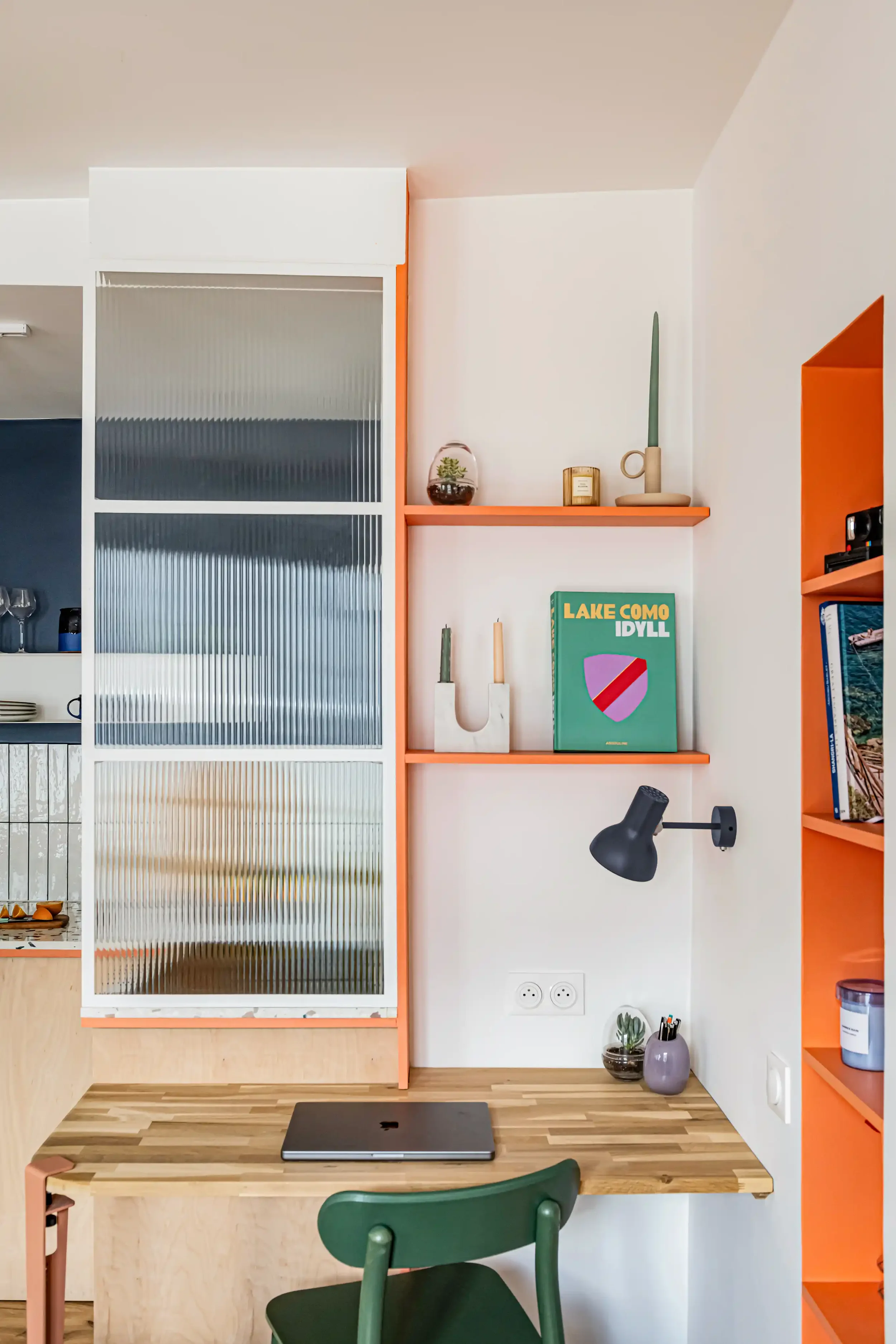 Petit bureau sur mesure orange intégré pour optimiser l'espace de travail dans un appartement parisien.