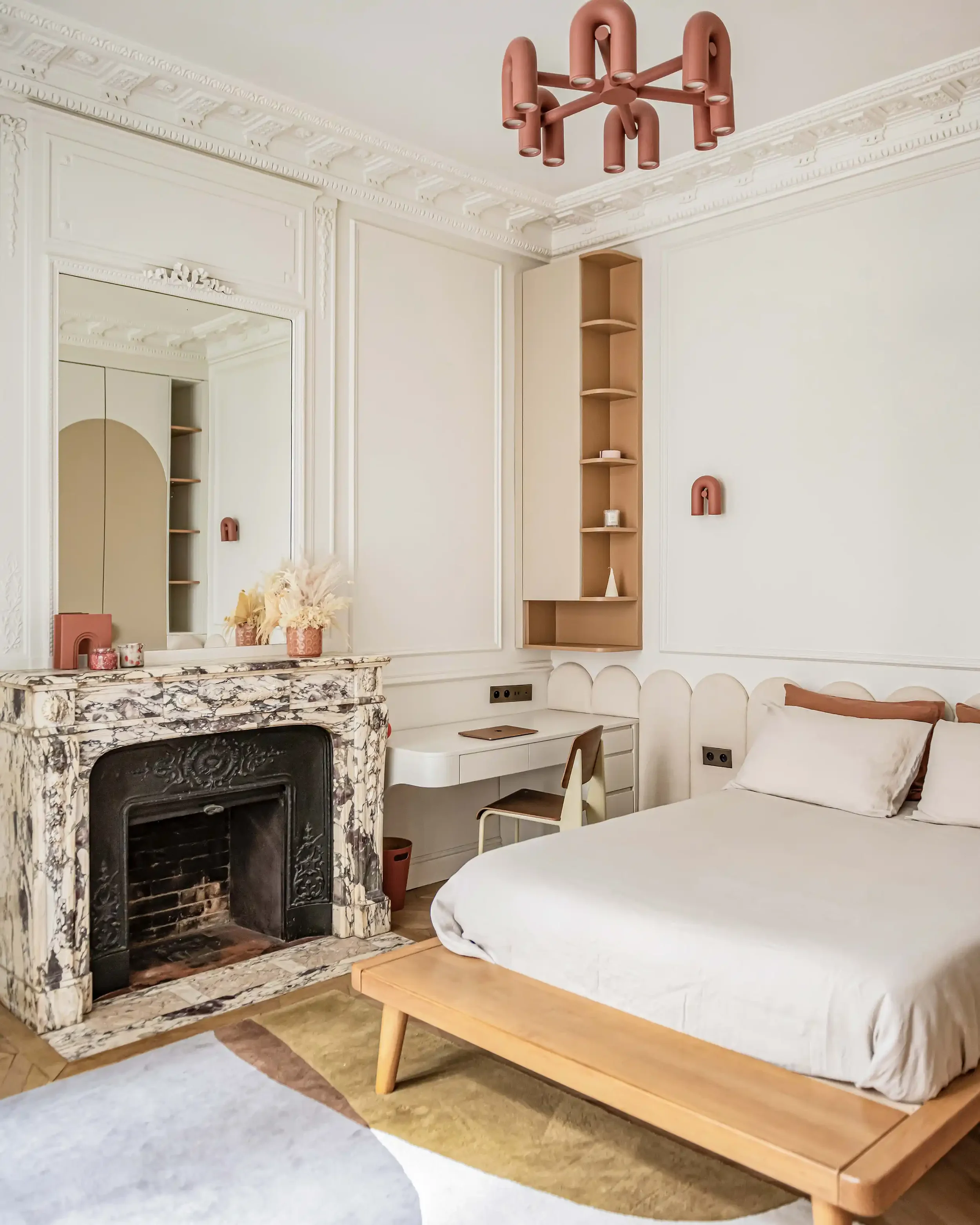 Coin bureau design installé à côté d'une cheminée ancienne en marbre dans une chambre de maître à Paris.