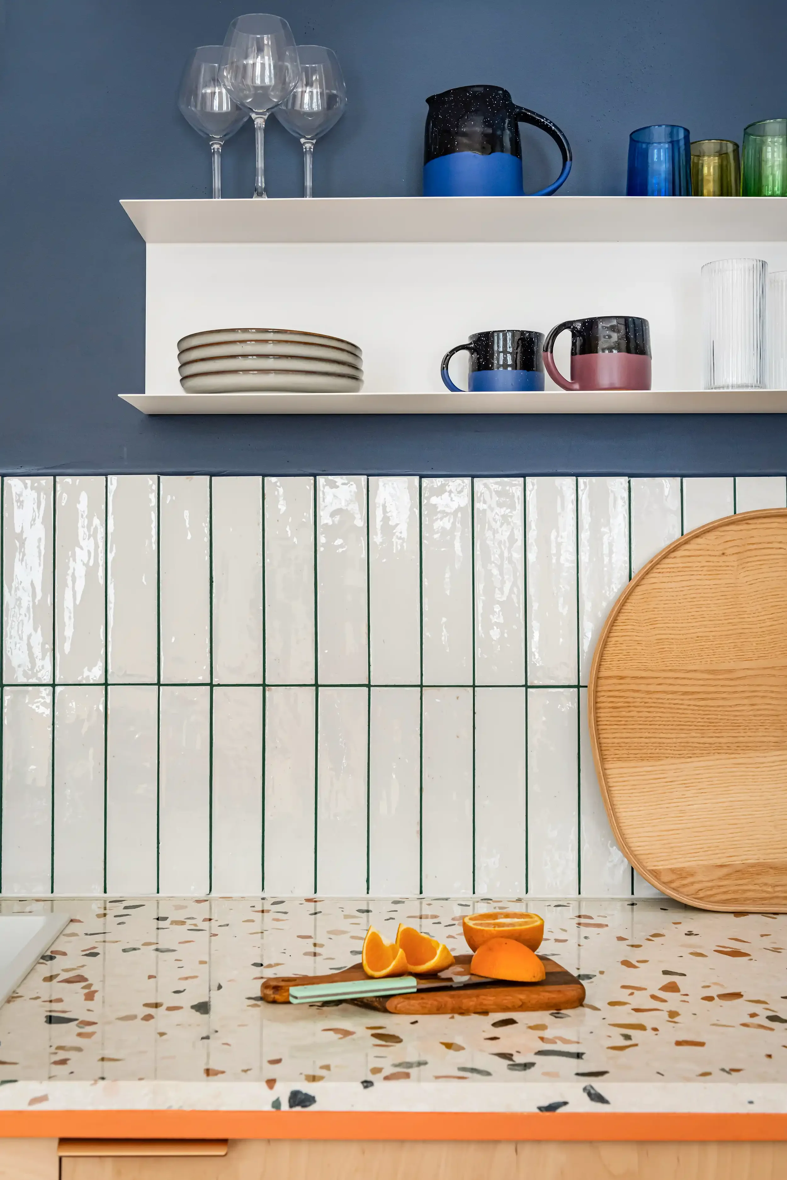 Zoom sur un plan de travail en terrazzo coloré avec crédence assortie dans une cuisine moderne.