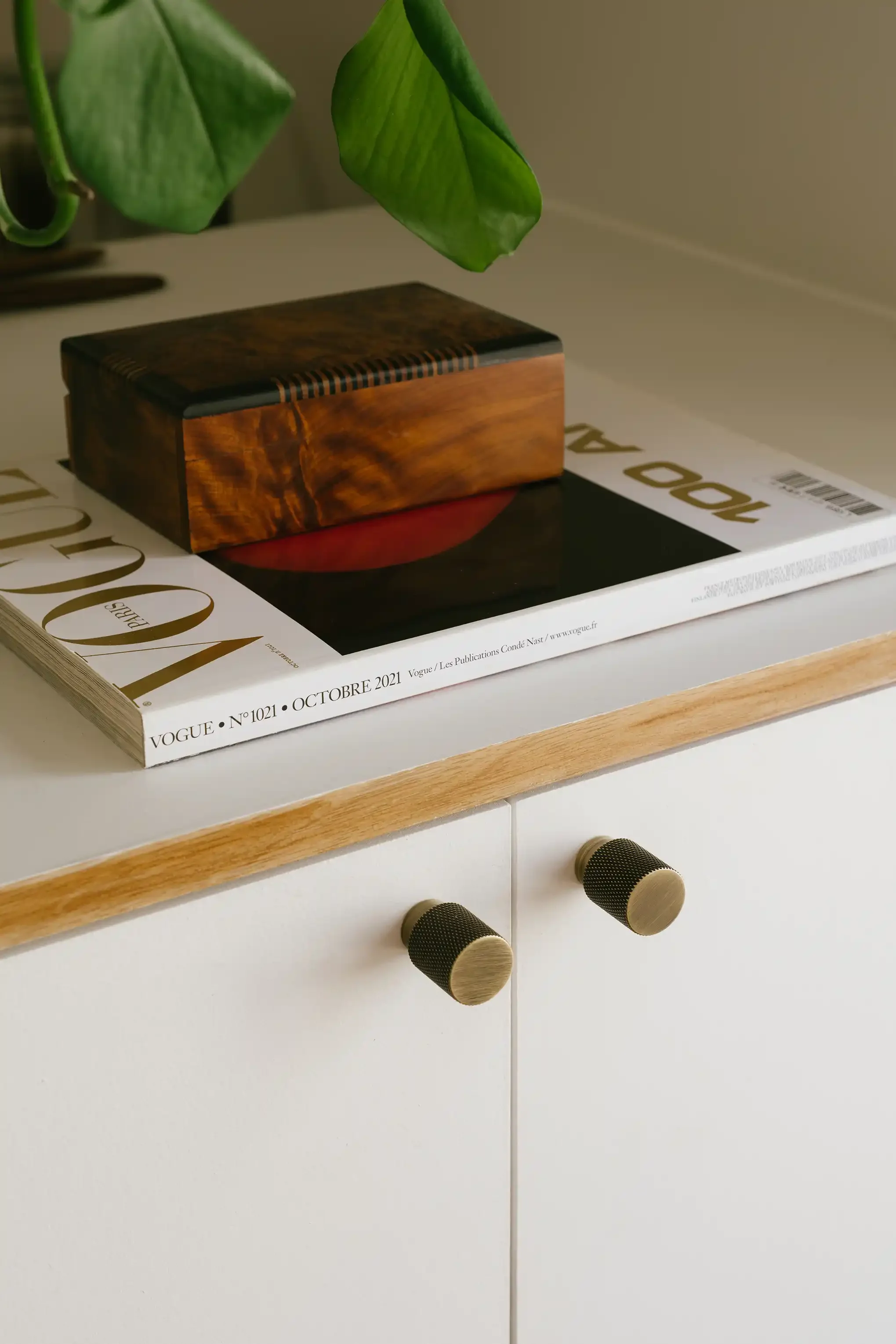 Zoom sur les poignées moletées en laiton d'un buffet blanc sur-mesure, élégance et finitions haut de gamme pour aménagement intérieur.