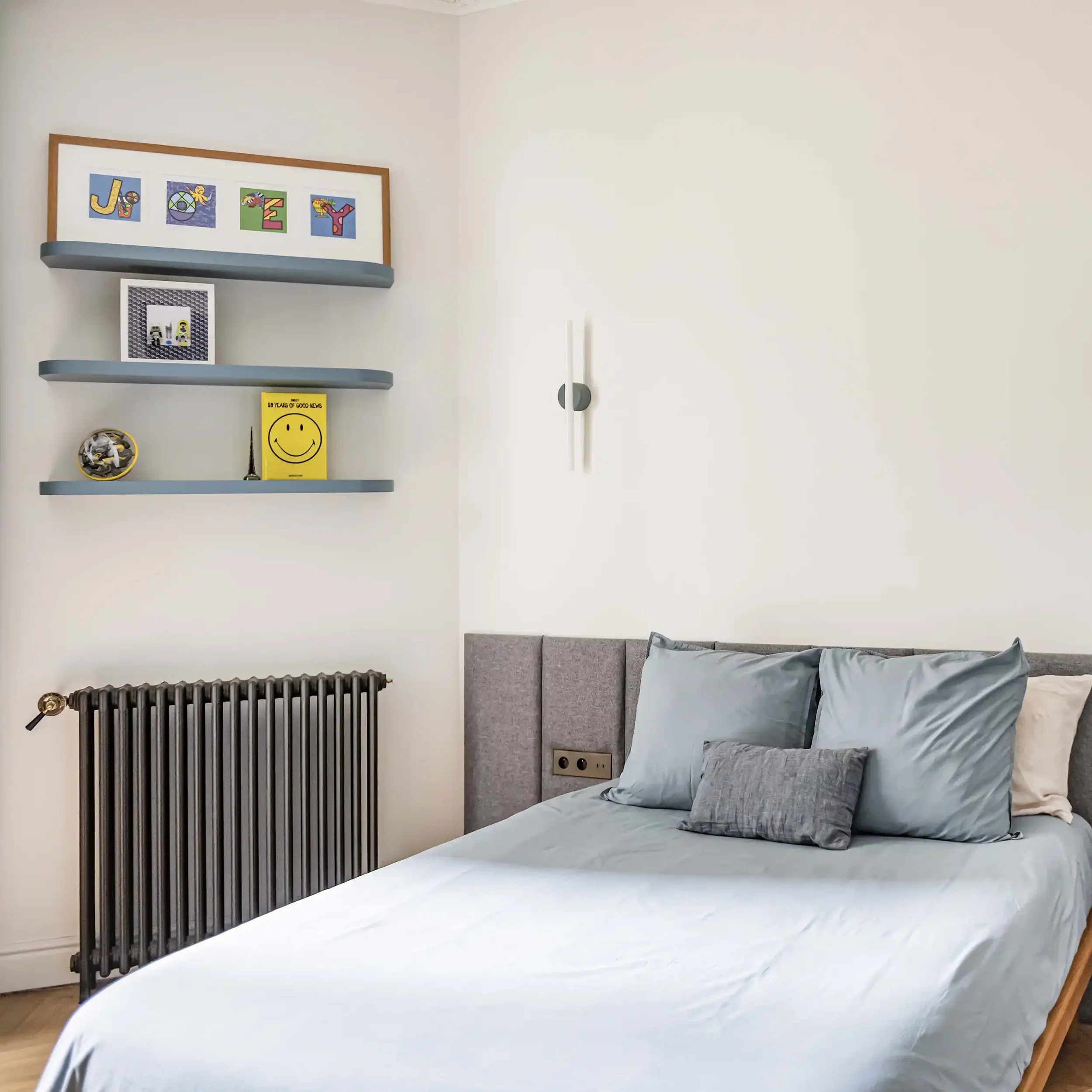 Chambre d'adolescent avec grand meuble de rangement bleu et blanc sur mesure, bureau intégré et parquet en chêne.