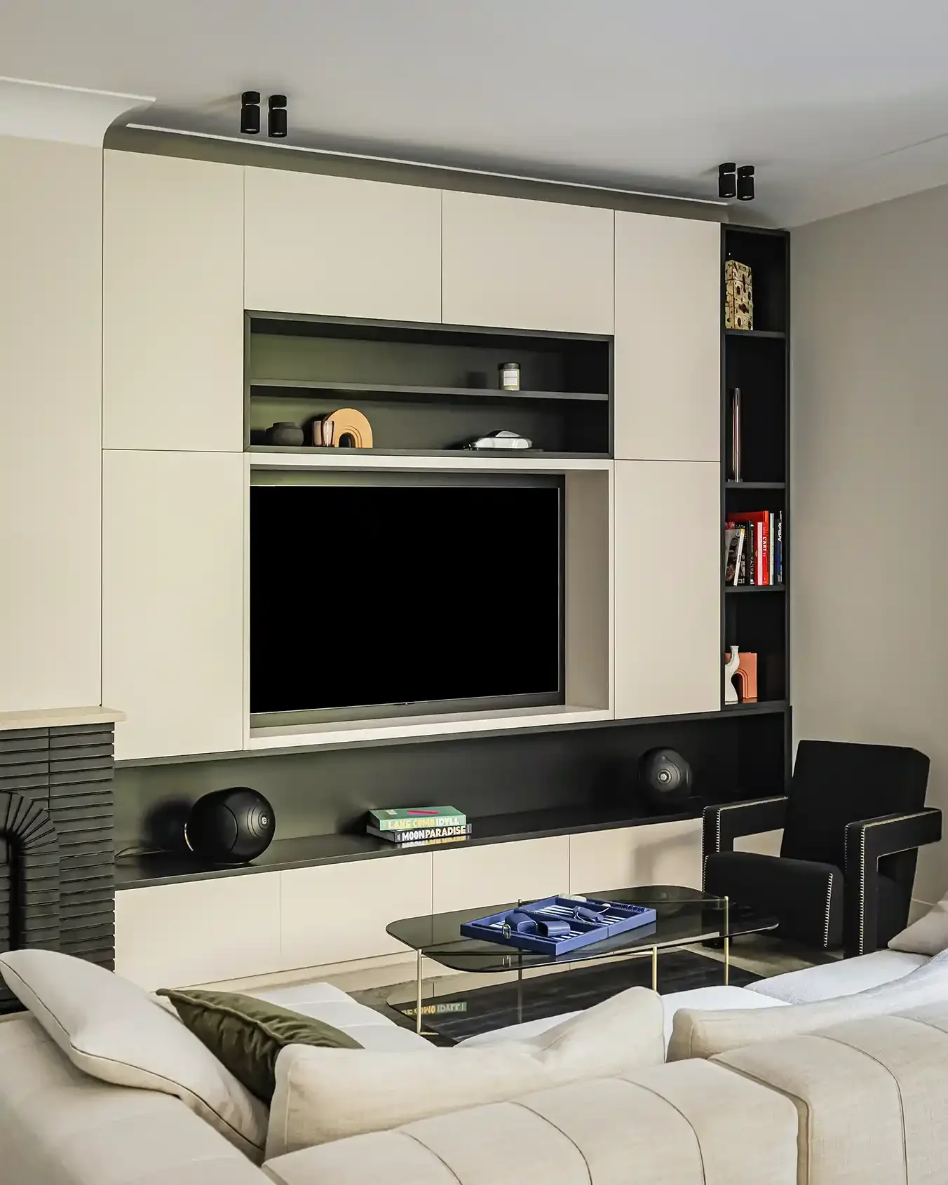 Meuble TV et bibliothèque sur-mesure aux lignes minimalistes beige et noir dans un salon parisien moderne.