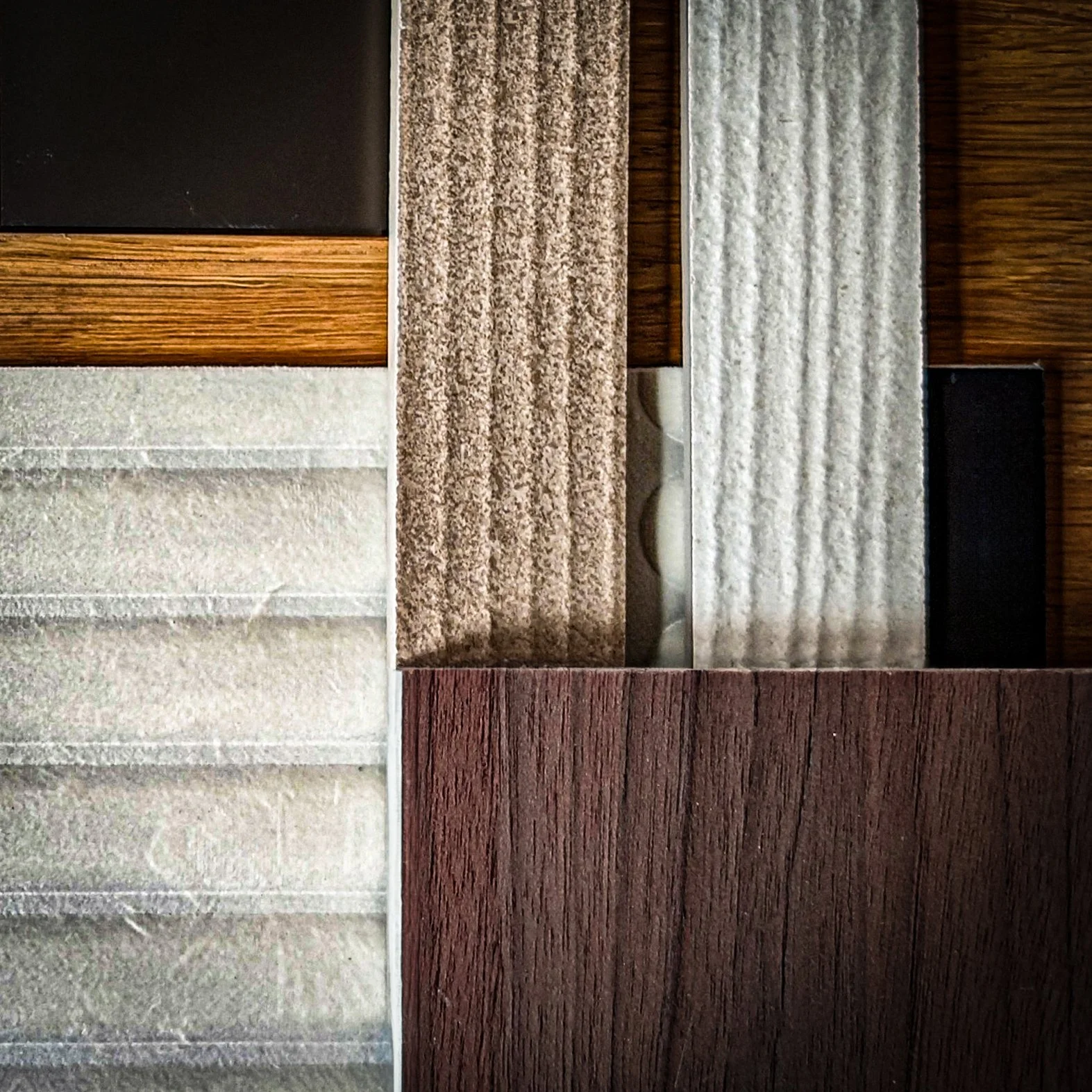 Agencement d'échantillons de matériaux aux textures variées, disposés en différents motifs et couleurs.