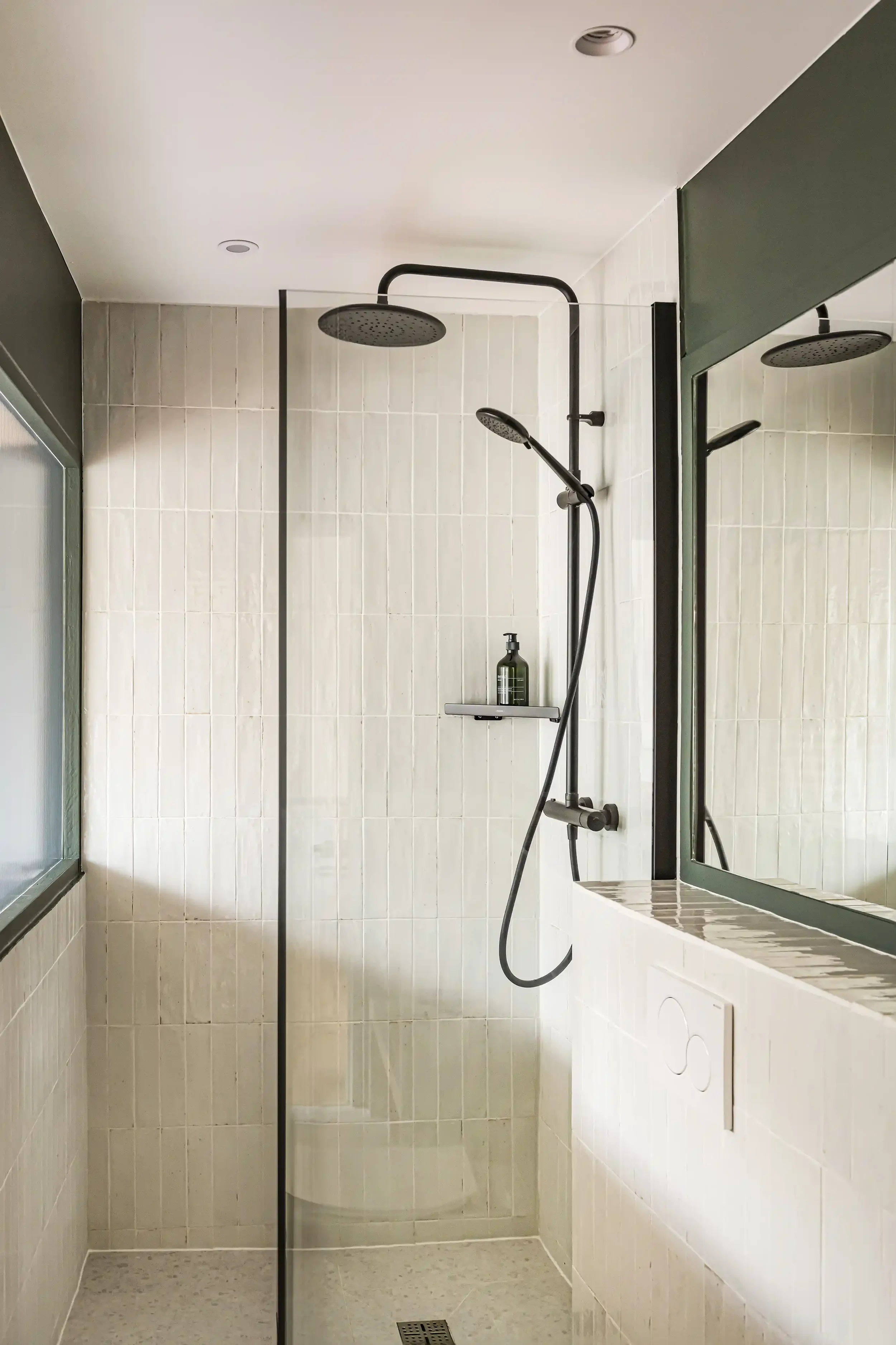 Douche moderne avec carrelage en zellige beige nacré et ensemble de robinetterie encastrée noir mat.
