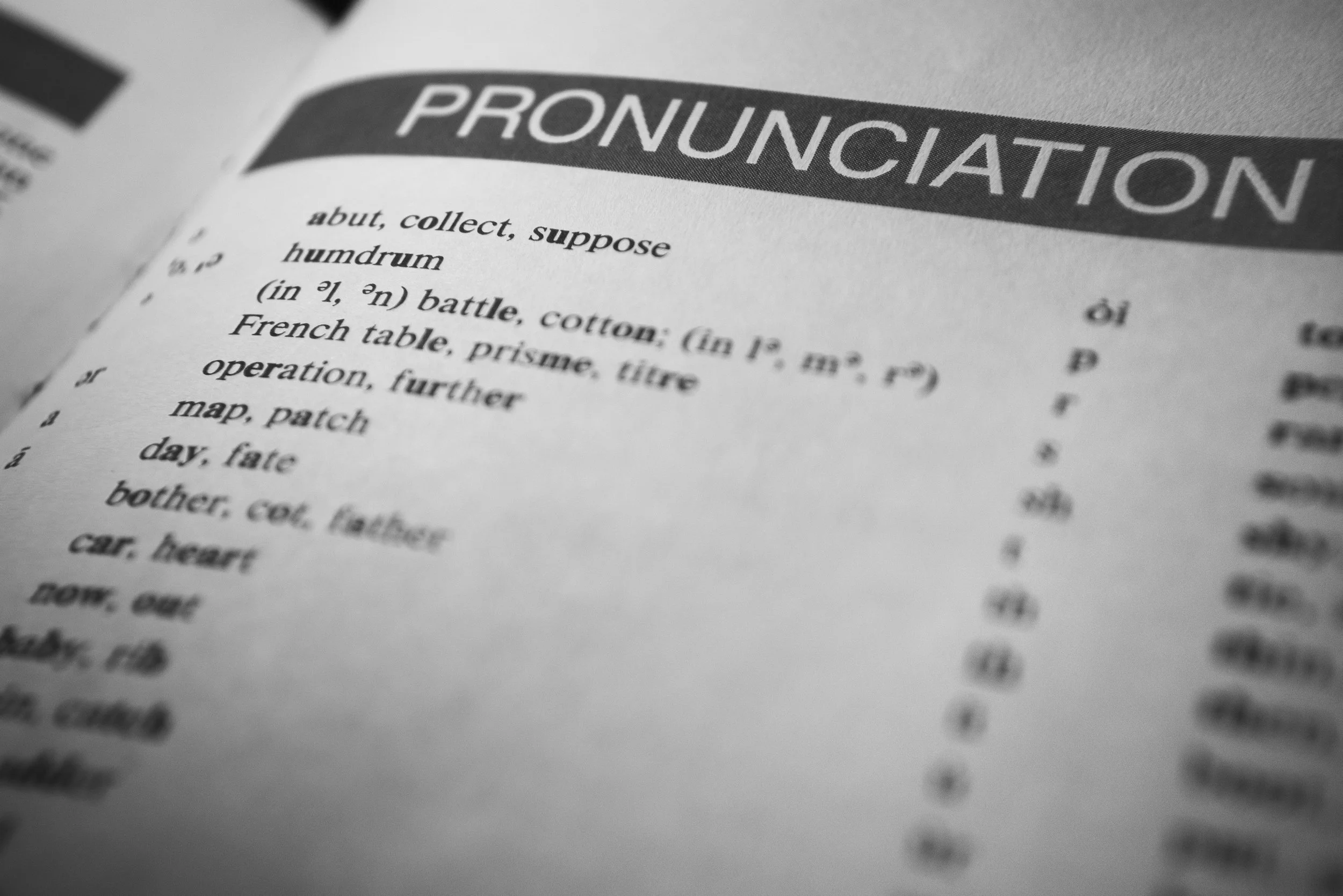 Close-up of a dictionary page with the word 'PRONUNCIATION' as the heading, listing various words and their definitions.