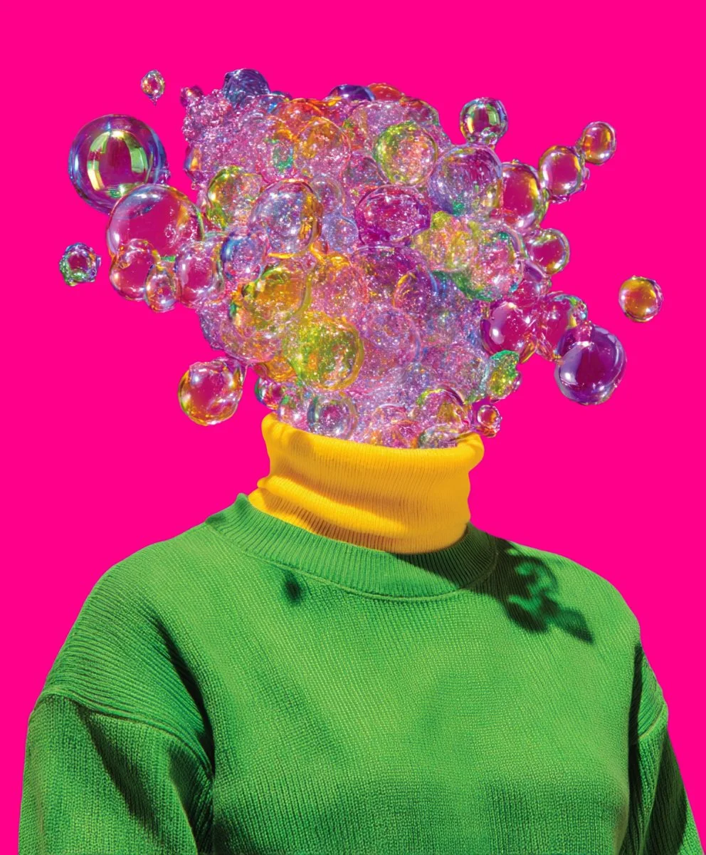 Person with a bubble-filled explosion for a head, wearing a green sweater and yellow neck warmer, against a hot pink background.
