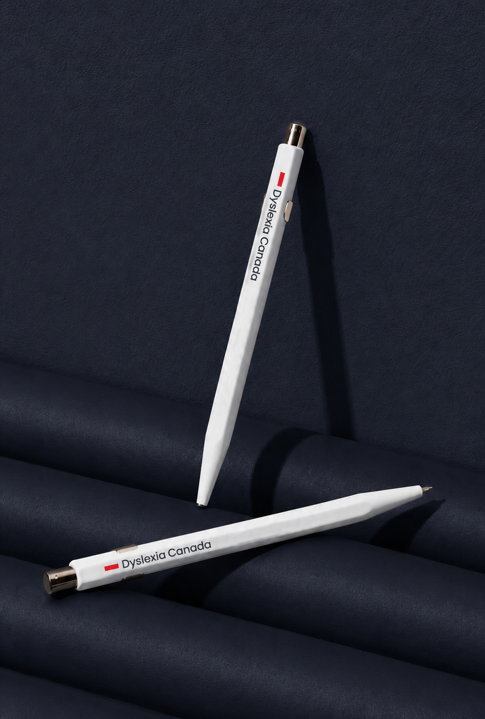 White branded pens featuring the Dyslexia Canada logo, designed as promotional merchandise for a national education nonprofit.