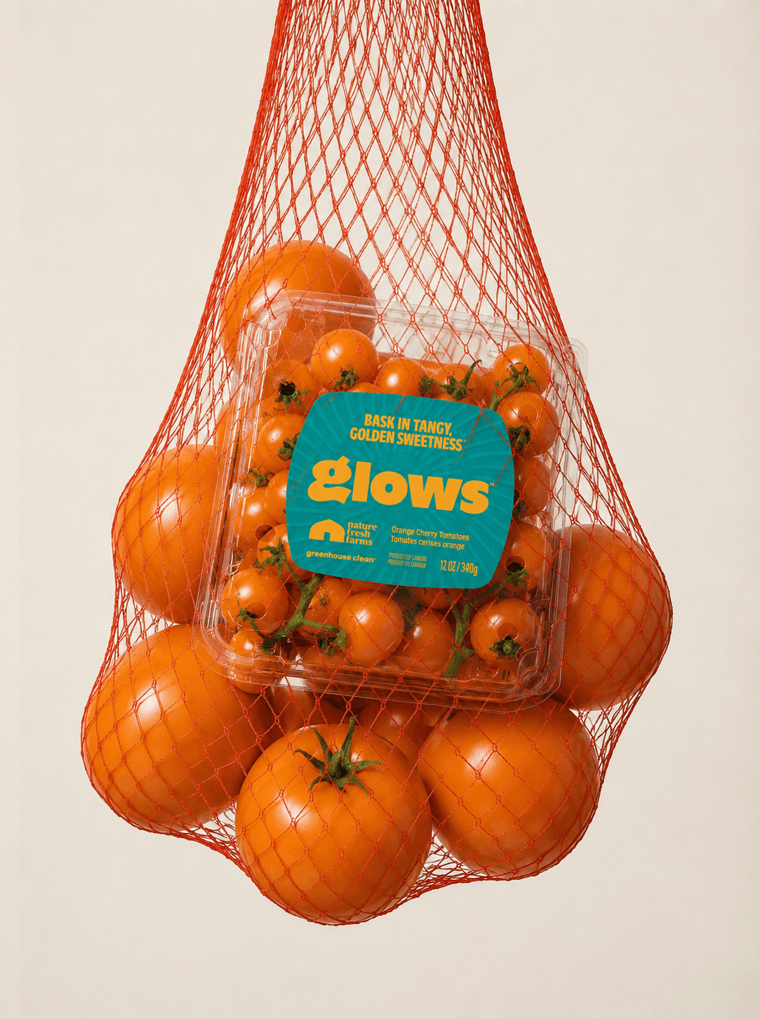 Orange tomatoes suspended in a reusable produce net with Nature Fresh Farms Glows cherry tomatoes, creating a bold AI-generated campaign visual that highlights fresh produce and vibrant color.