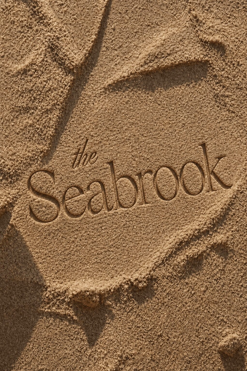 AI-designed luxury hospitality logo for The Seabrook showcased in sand, highlighting custom brand identity, creative direction, and destination branding.