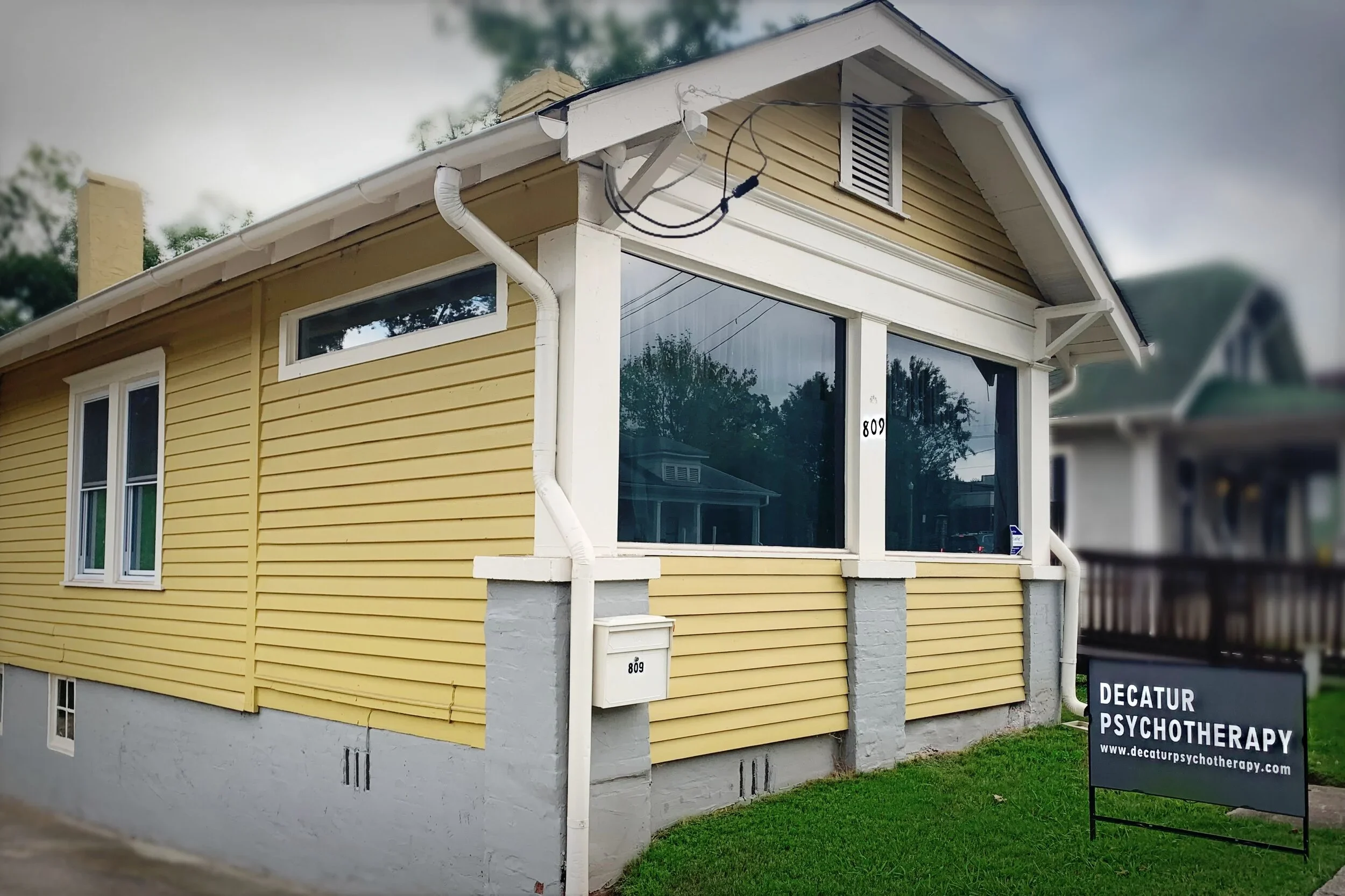 yellow house with sign that says "Decatur Psychotherapy"