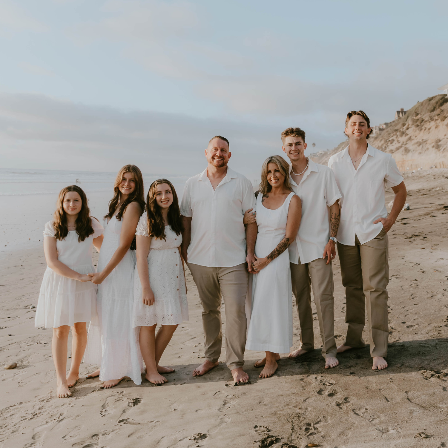 husband and wife with five kids on beach, owners of Universal Modular, Inc.