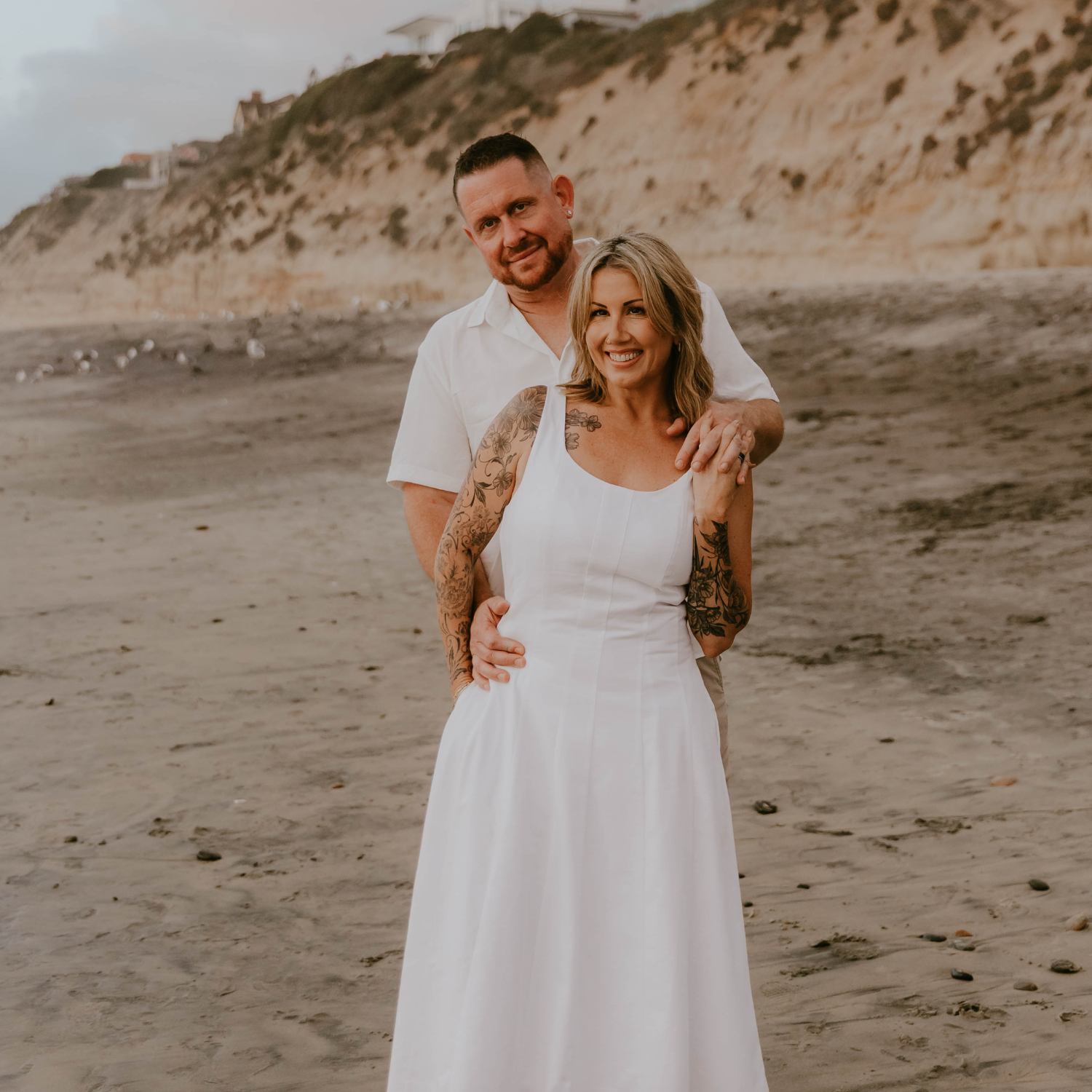 husband and wife, owners of Universal Modular, Inc., dressed in white on beach