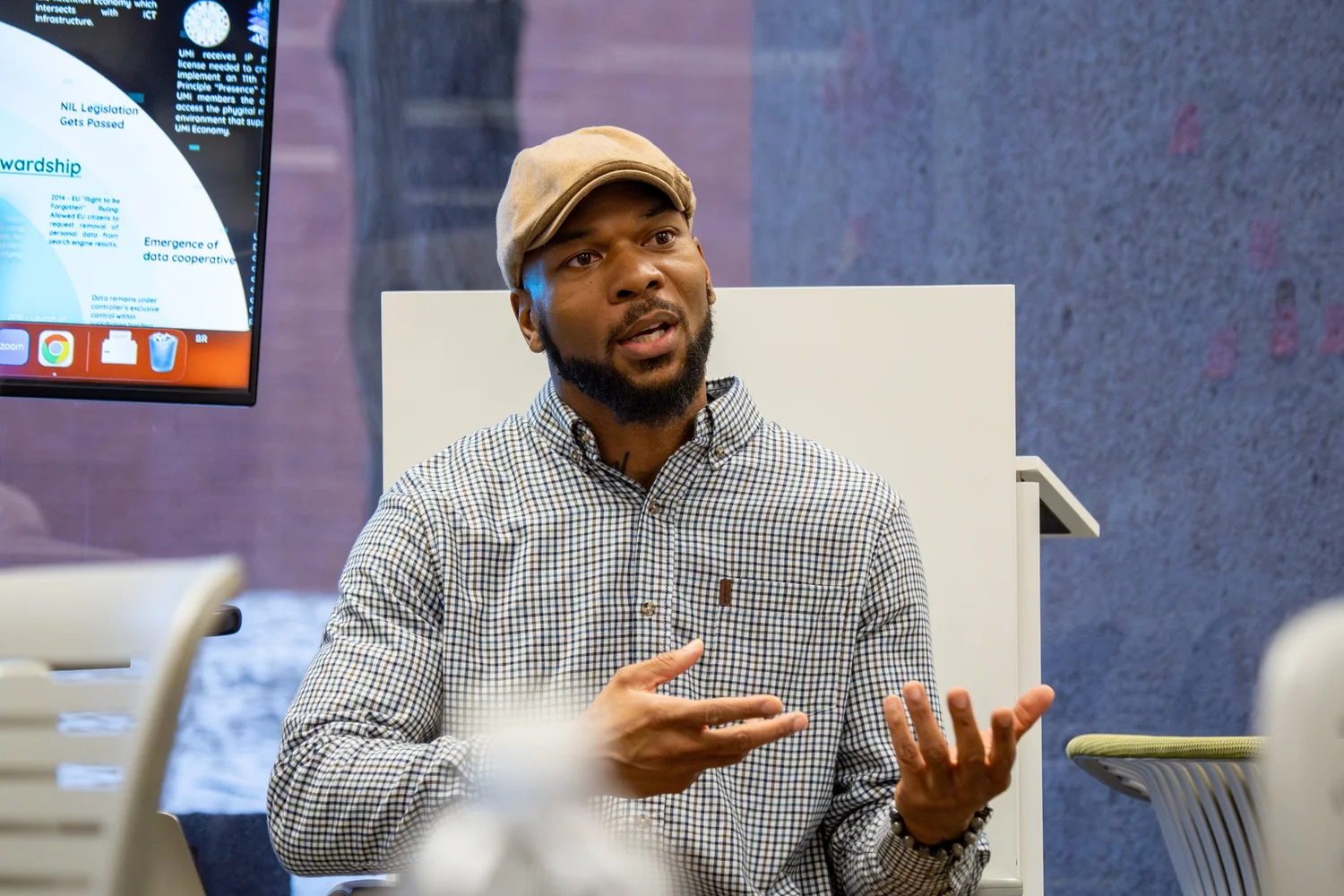 Guest speaker addressing a seminar group in a modern classroom — campus talk photography.