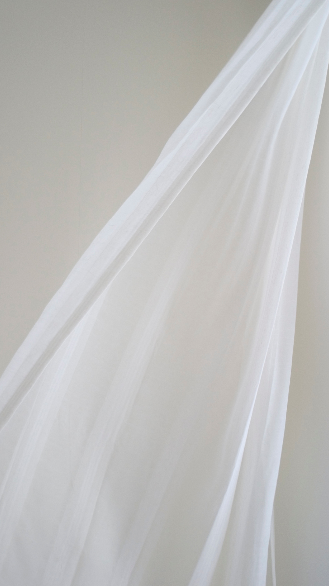 Sunset over the ocean with pink, orange, and purple sky, calm water, and a small boat in the distance.