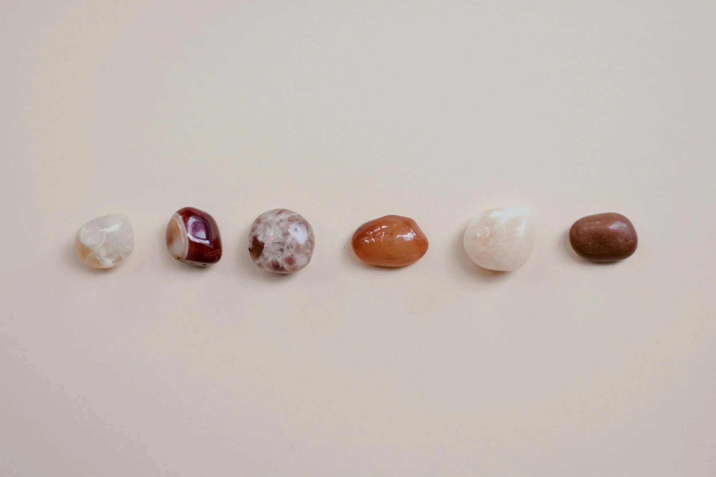 Aerial view of the ocean with two boats creating wakes, rocky shoreline with green trees and terraced landscape in the foreground, and a blue sky with some clouds.
