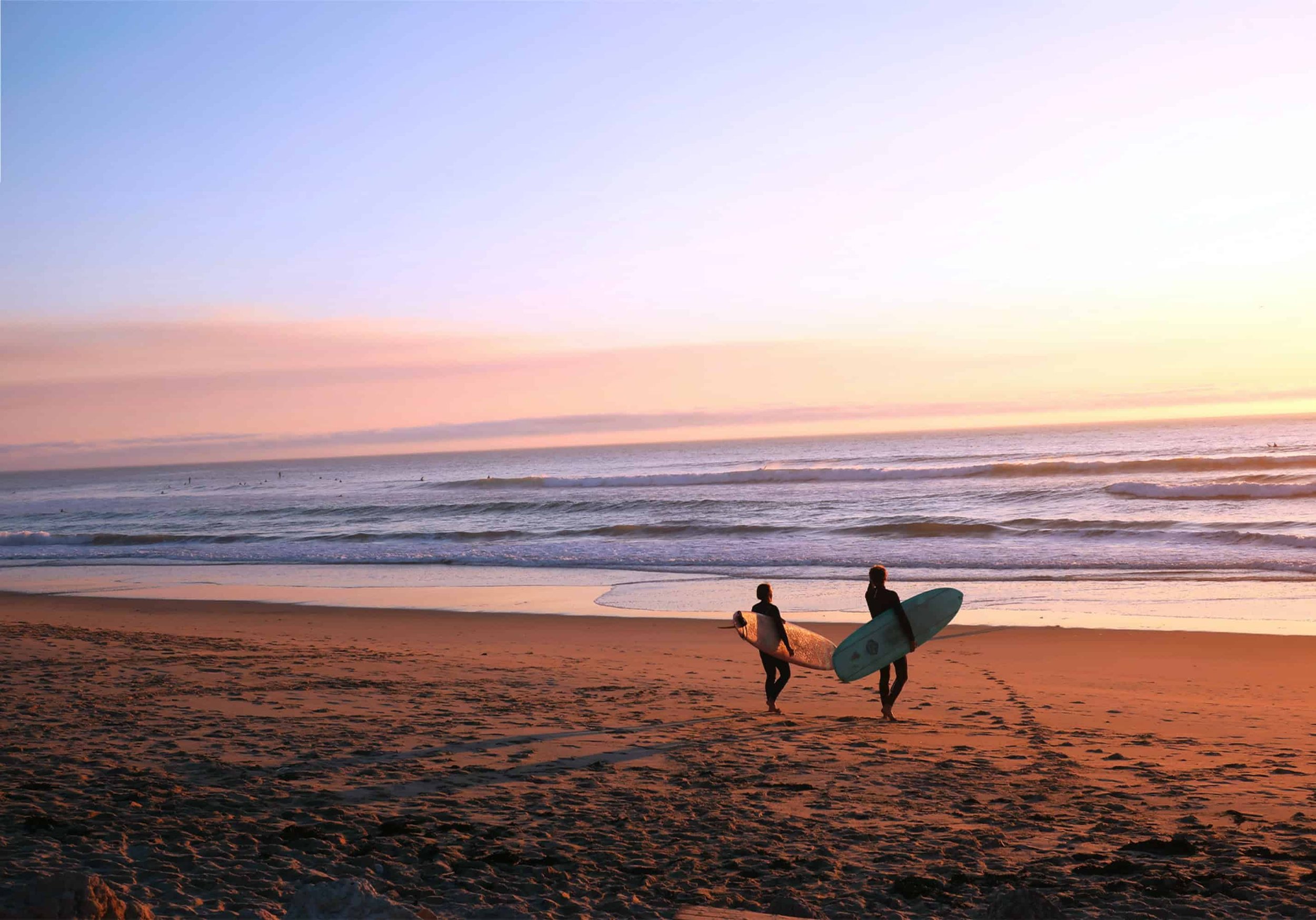 Surfers’ Dusk is a print of a beach at twilight, with surfers deciding if there is time in the fading light for one last ride.
