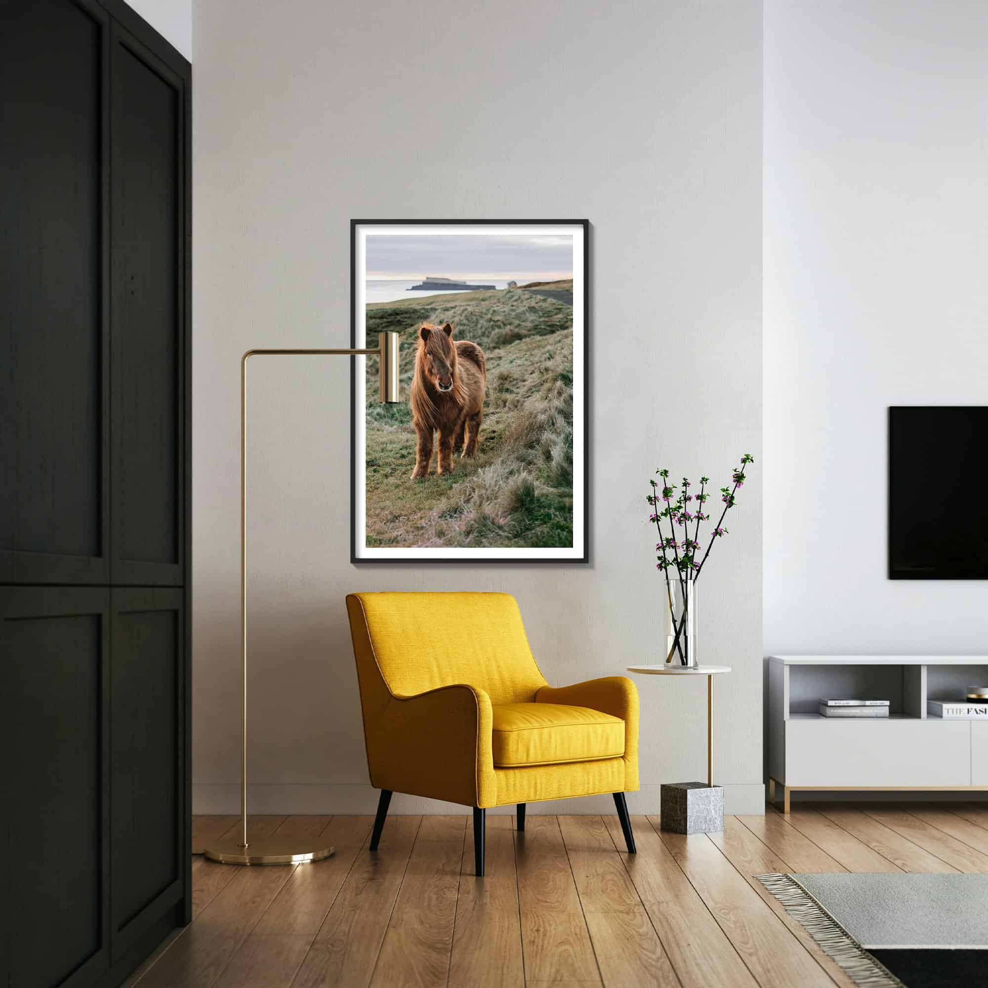 Icelandic horse against a pink and grey sky overlooking the ocean hung on wall in living room with wood frame.