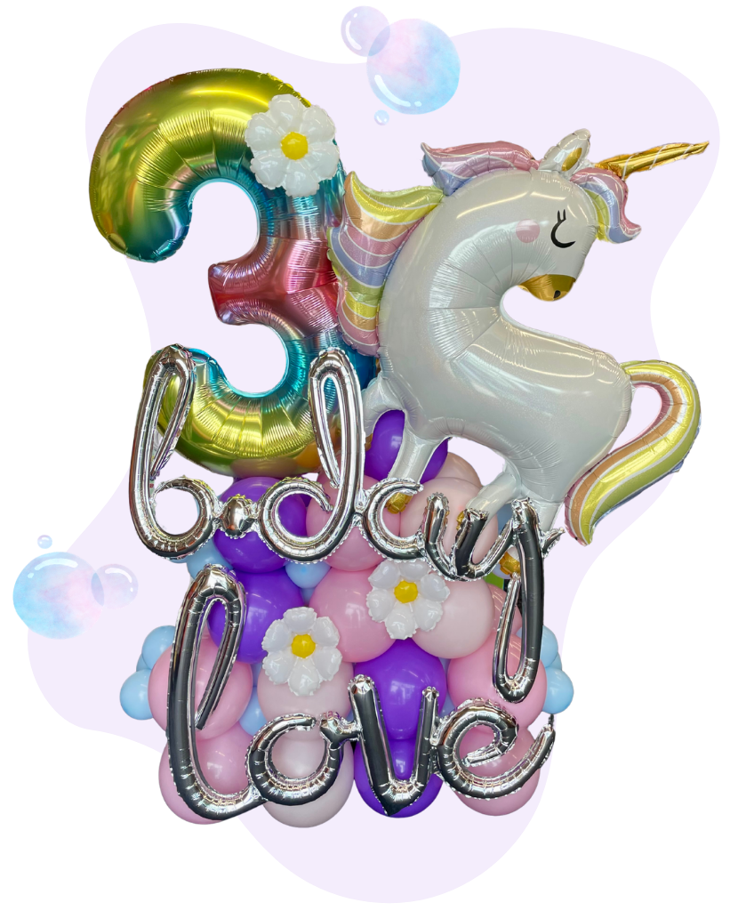 Colorful balloons including a large gold and rainbow number 3, a white unicorn with a rainbow mane and horn, the words "baby love" in silver balloons, and white flowers with yellow centers, with a pink background