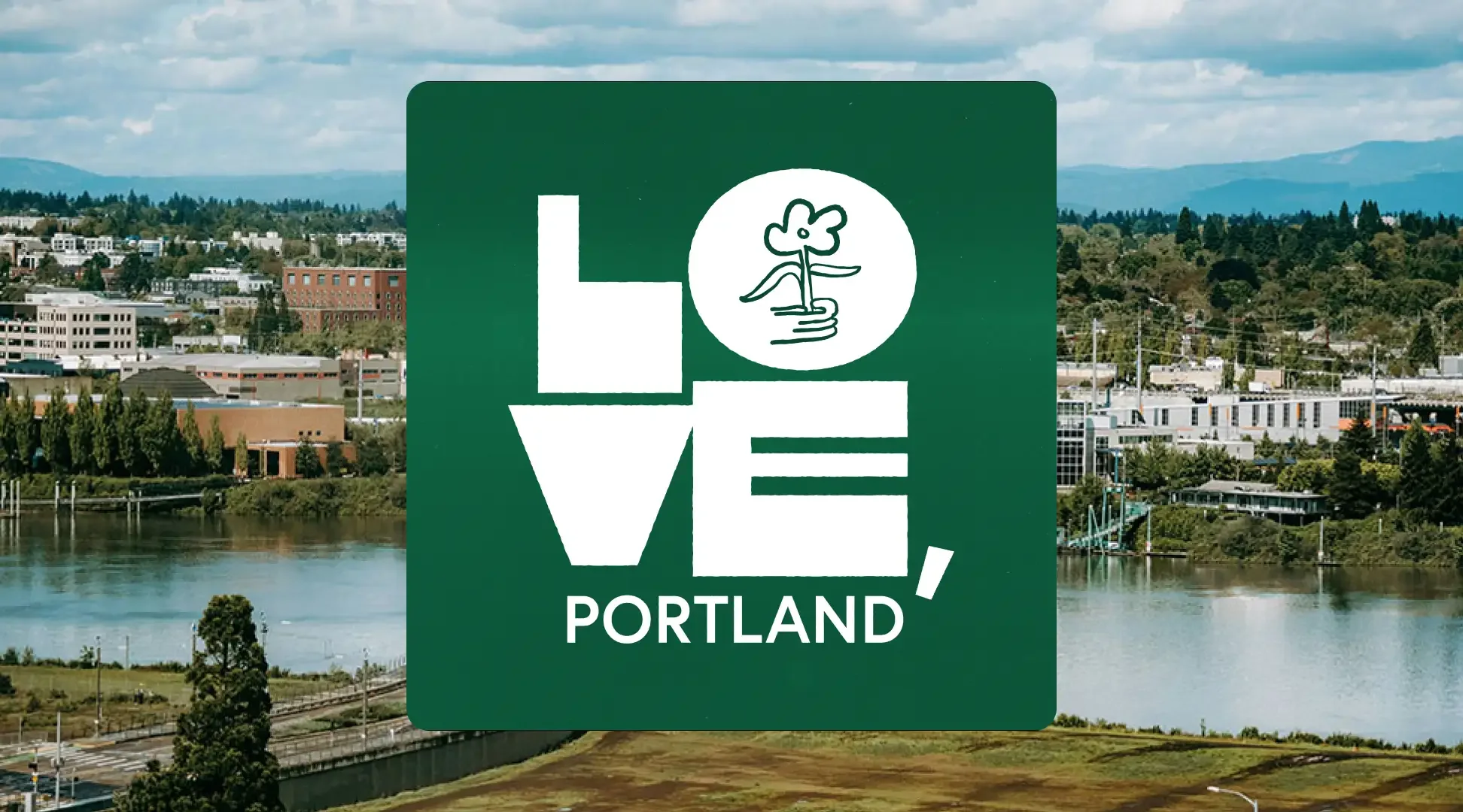 Green Portland sign with the word LOVE arranged vertically and a small flower illustration inside a circle, set against an urban landscape with buildings, trees, and a river in Portland.