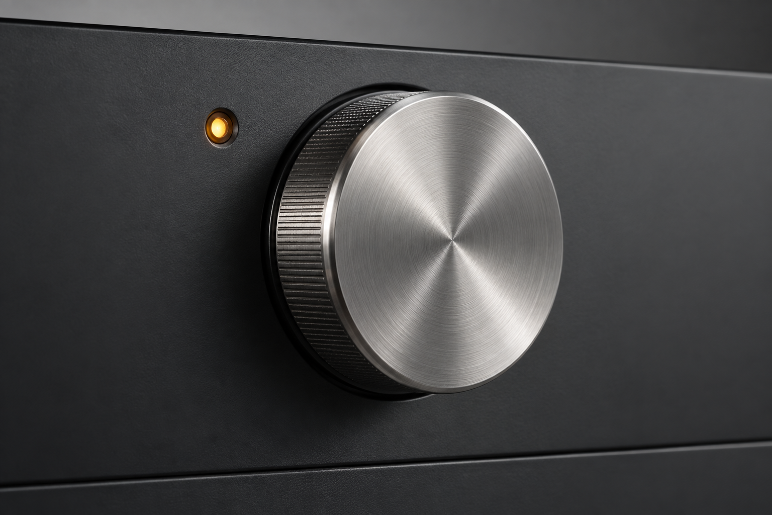Conceptual appliance panel with a textured metal dial and an amber indicator light.