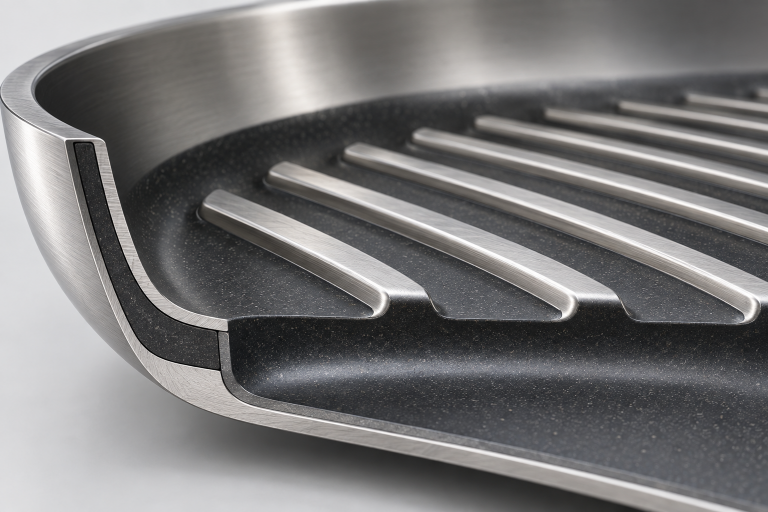 Close conceptual view of raised steel ribs above a recessed nonstick cooking surface.