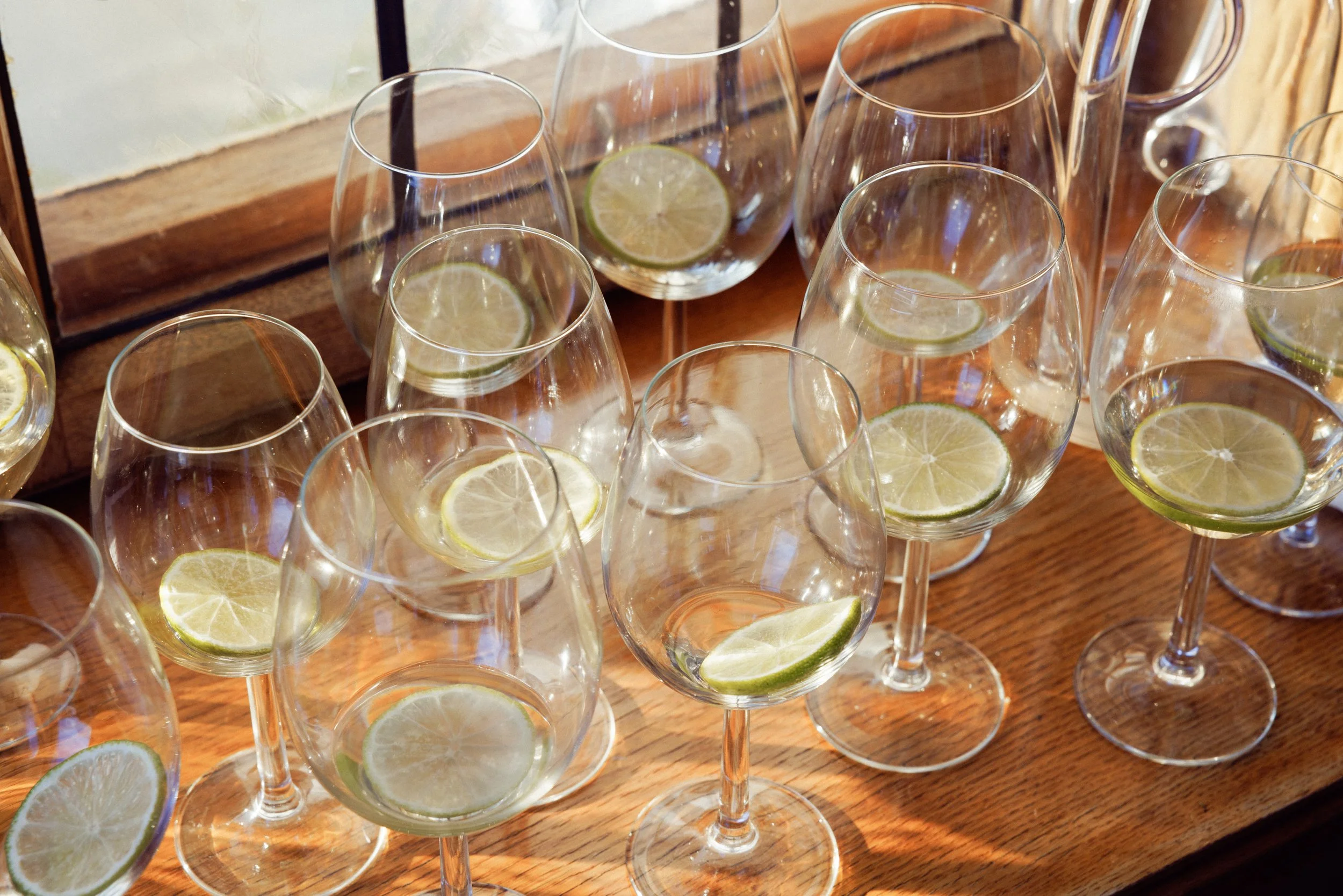 Tall med isvann og sitronskiver på en trebord.