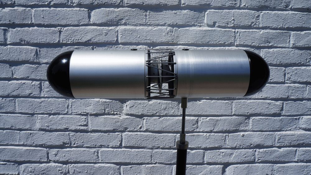 Qoms2 monopole sound source mounted on tripod for room acoustics testing