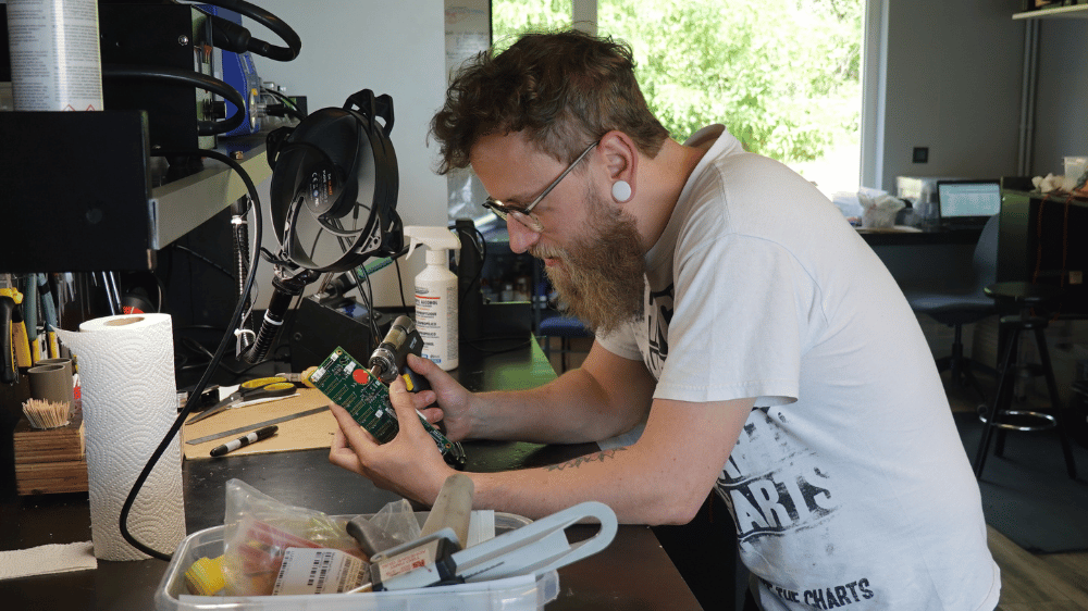 Qsources team assembling and inspecting components at a workbench