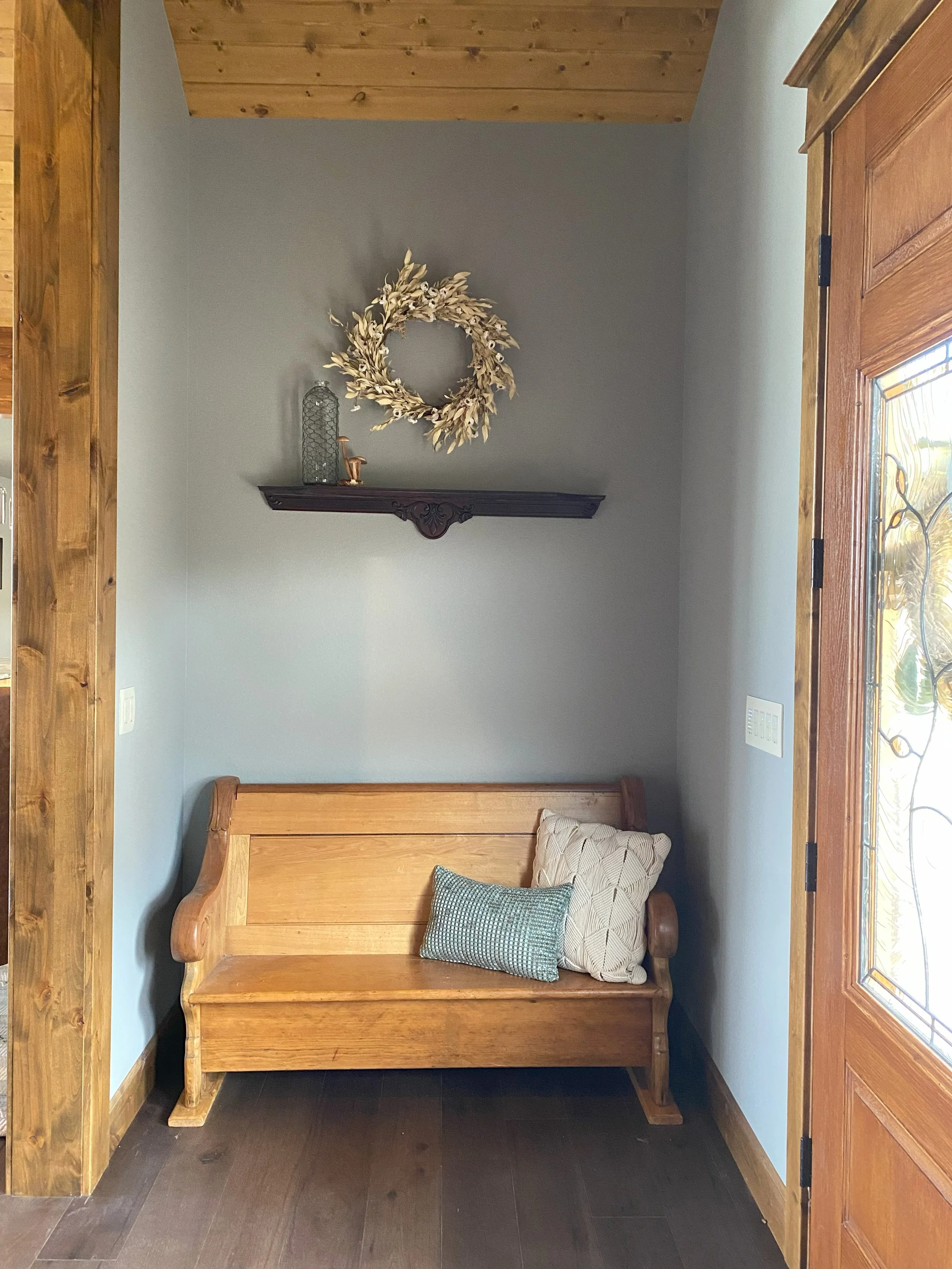Foyer: backboard of the repurposed dresser vanity as a floating shelf over salvaged church pew