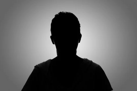 Silhouette of a person against a gray background.