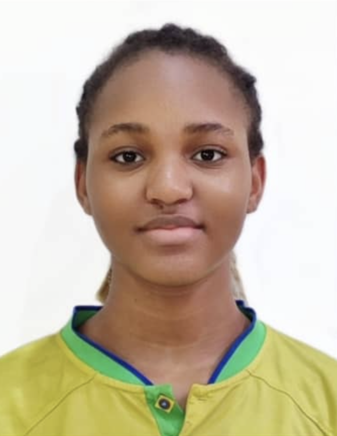 A young woman with dark hair styled in braids, wearing a yellow sports jersey with green and blue accents, standing against a plain white background.