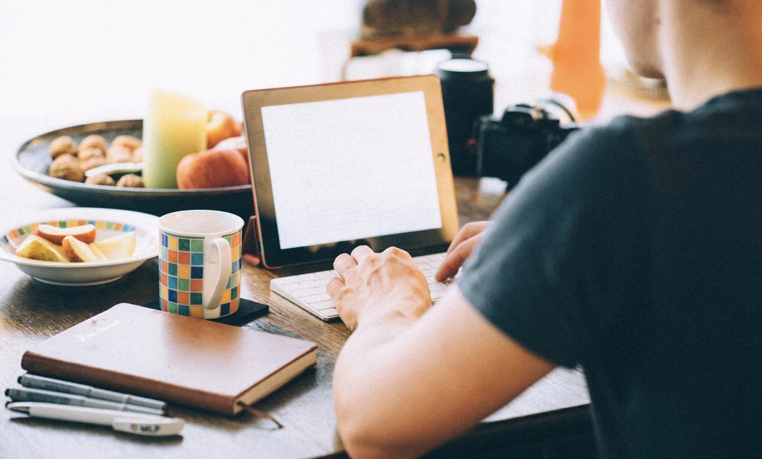 Man sitting at table with tablet.